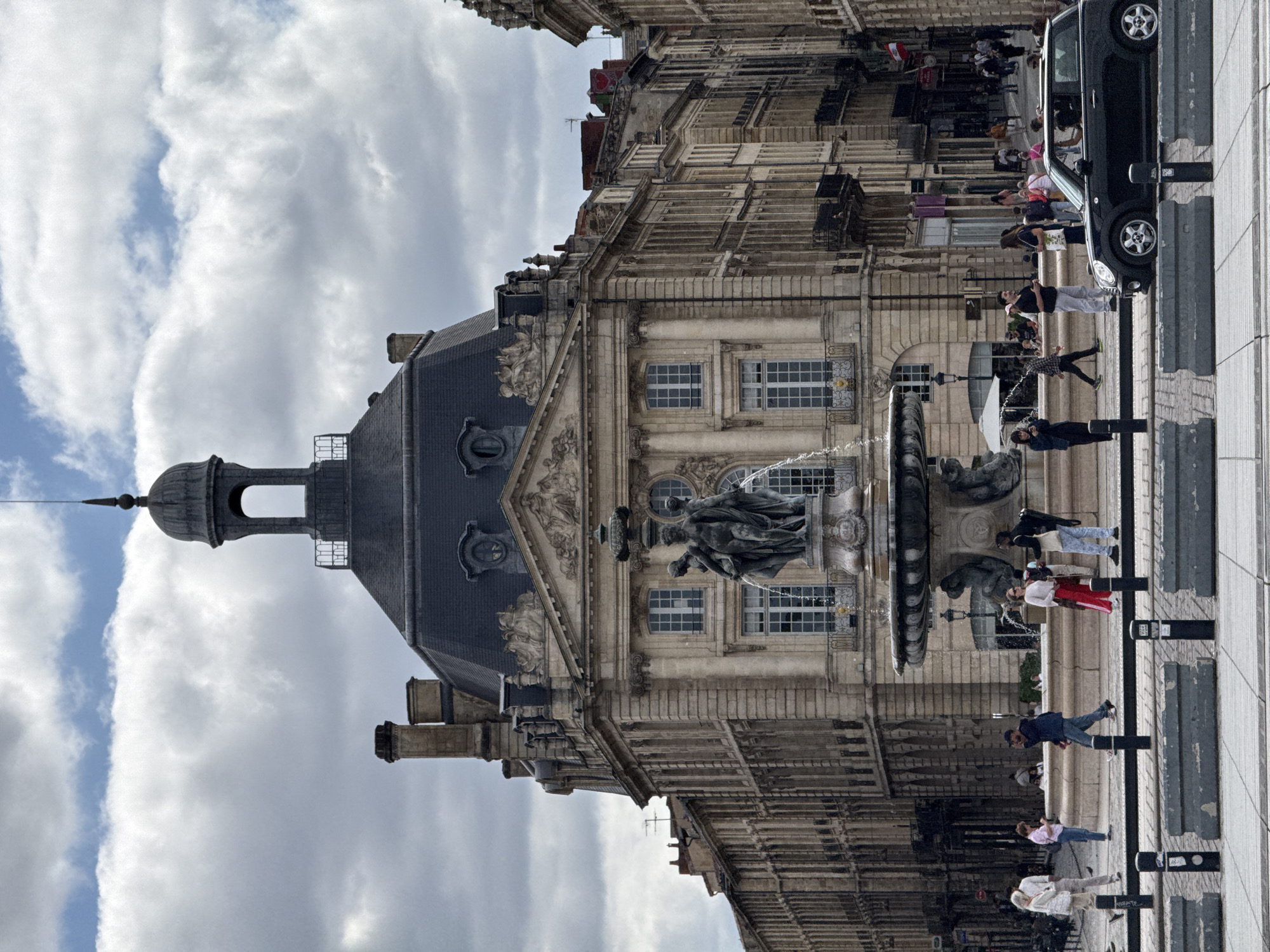 Tourist documents Place de la Bourse landmarks during cloudy afternoon