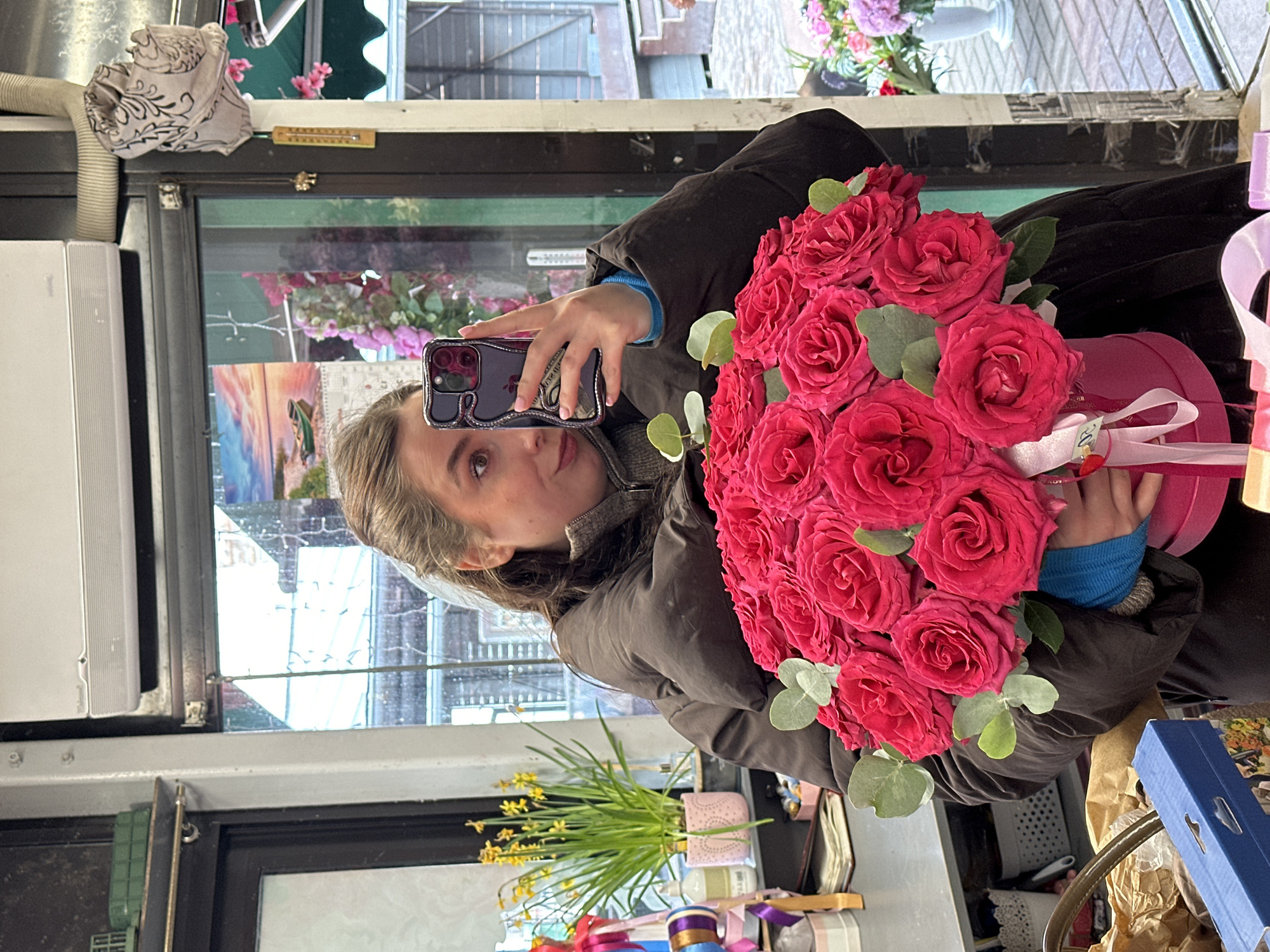 Woman takes selfie with pink roses at Latvian flower shop