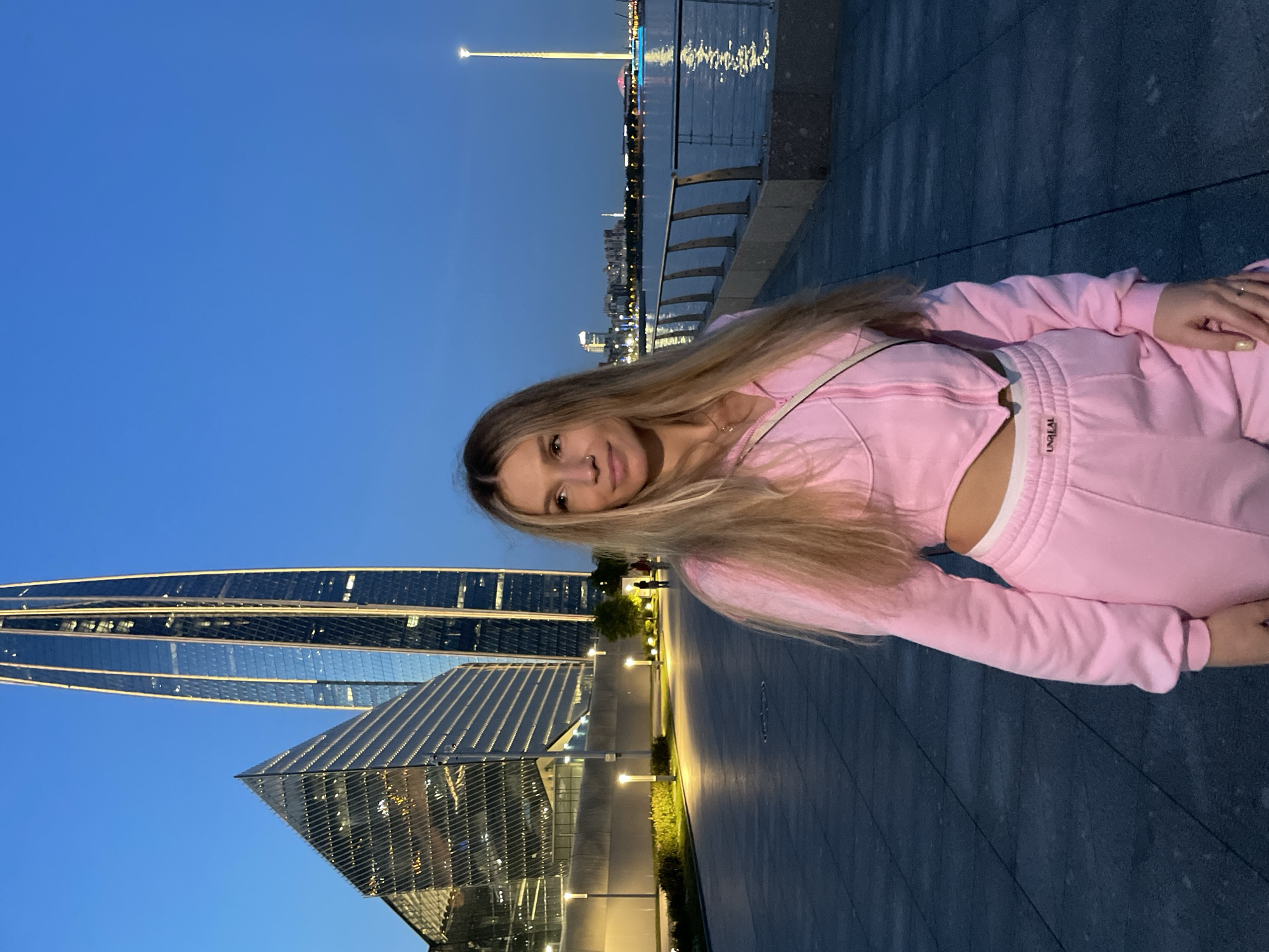 Woman in pink tracksuit spotted at Peterhof waterfront during dusk
