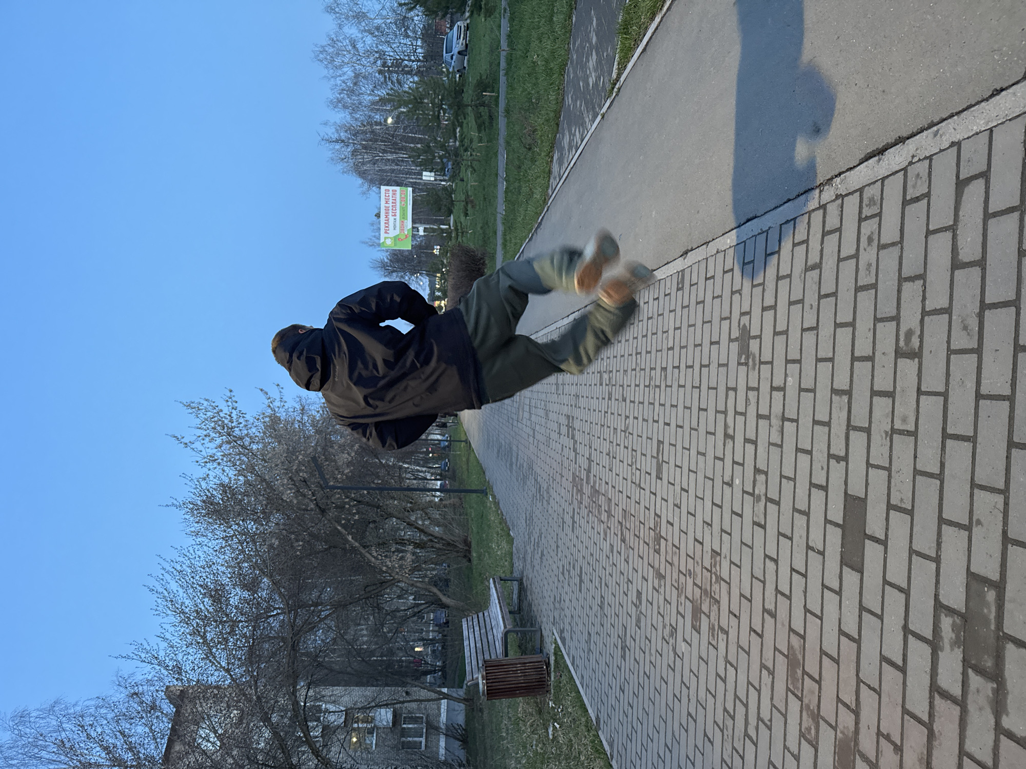 Person captured jumping mid-air on pathway in Chaikovsky