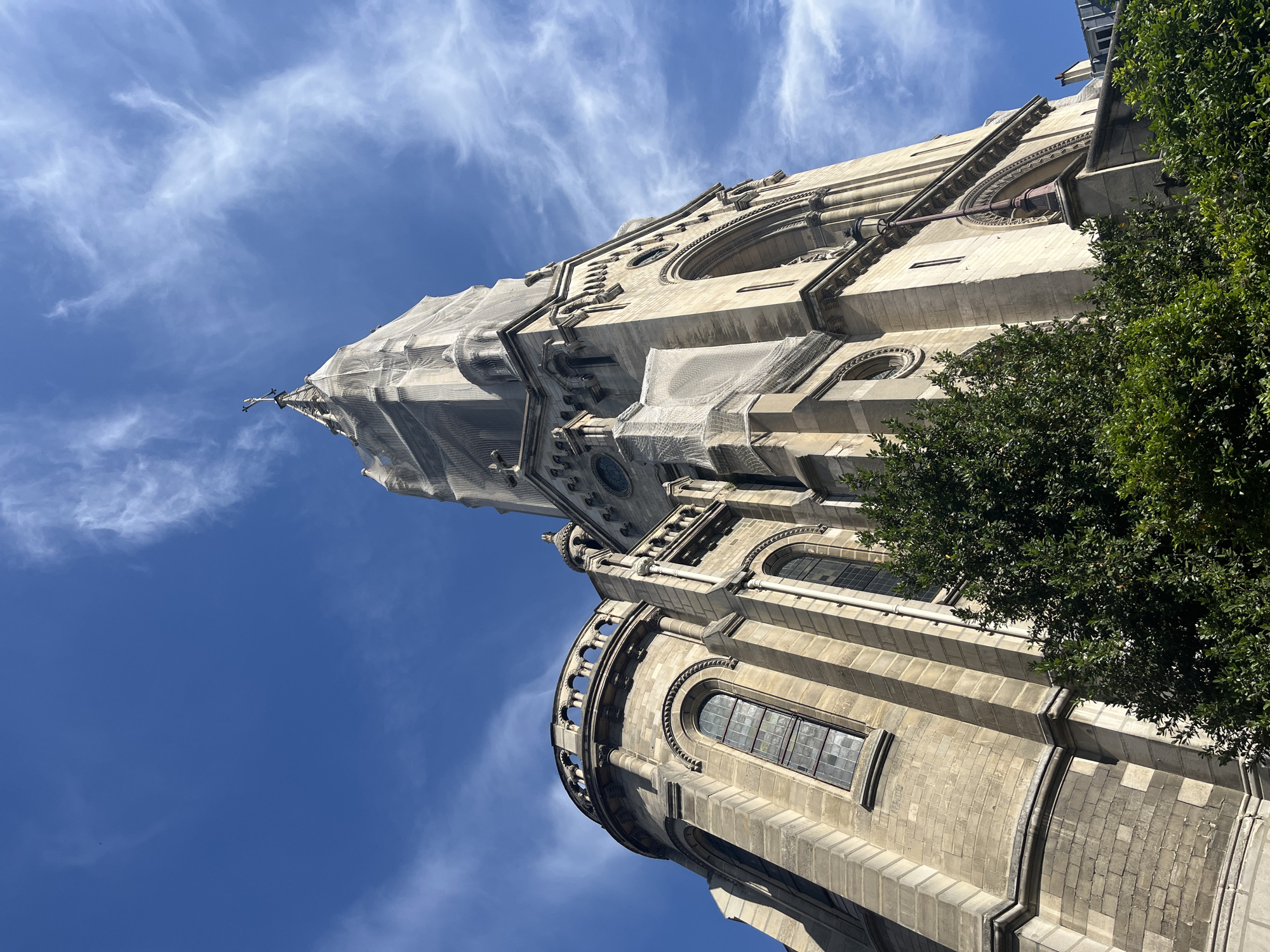 Parisian church spire mid-renovation, draped in white netting