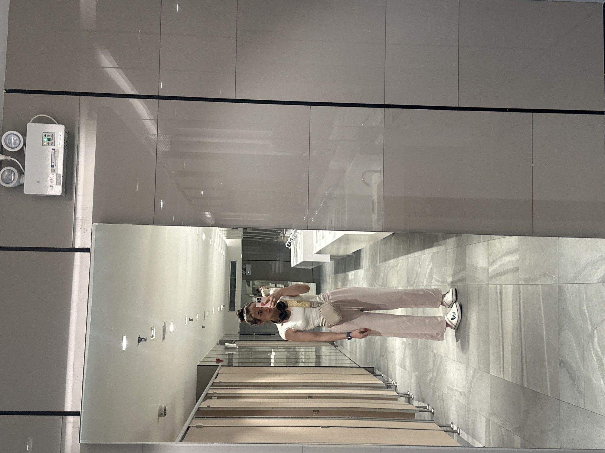 Woman takes selfie in public restroom mirror in Thailand