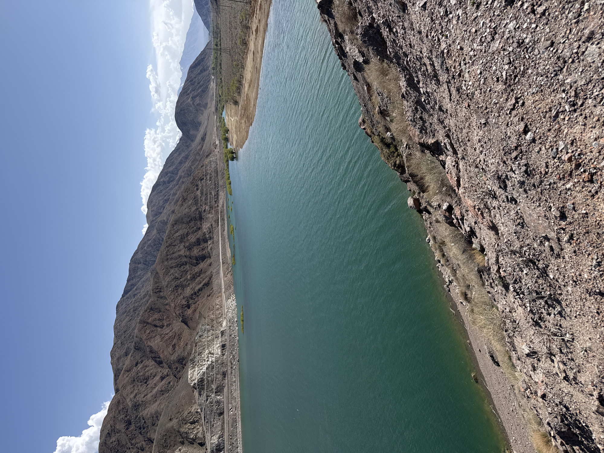 Tourist photographs turquoise mountain lake in Kyrgyzstan
