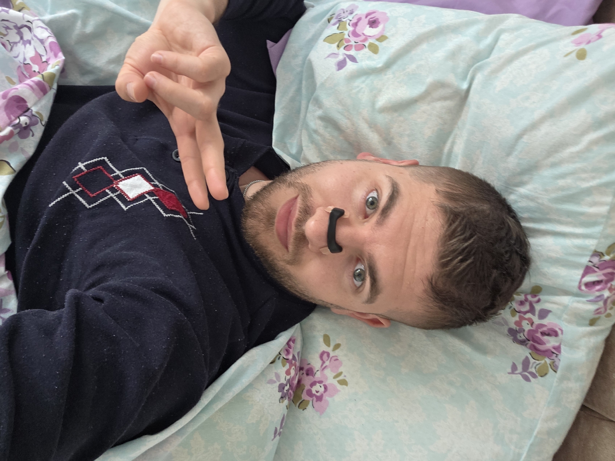 Man photographed in bed wearing patterned sweater in Bulgaria