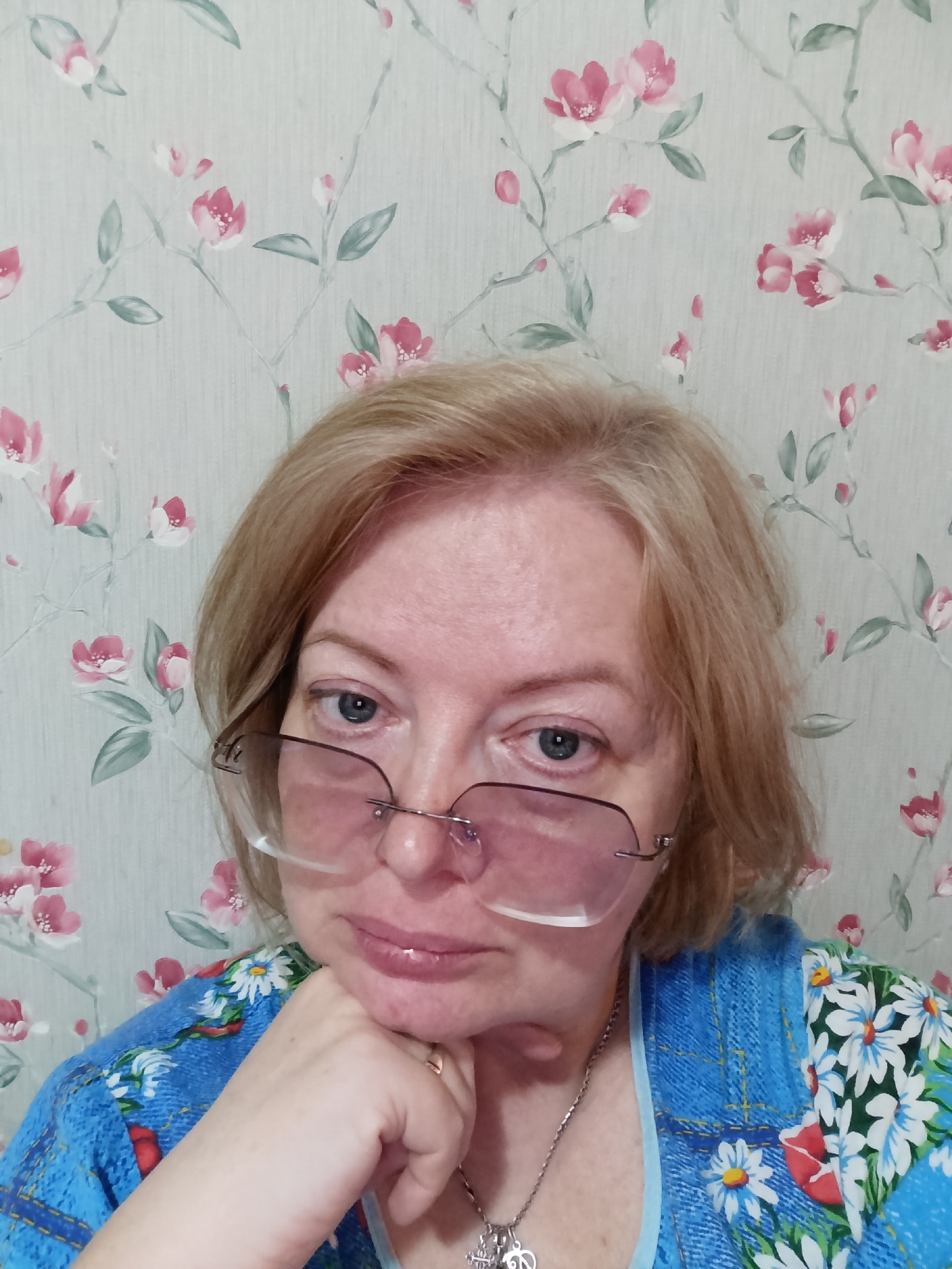 Woman poses for photo in blue floral shirt