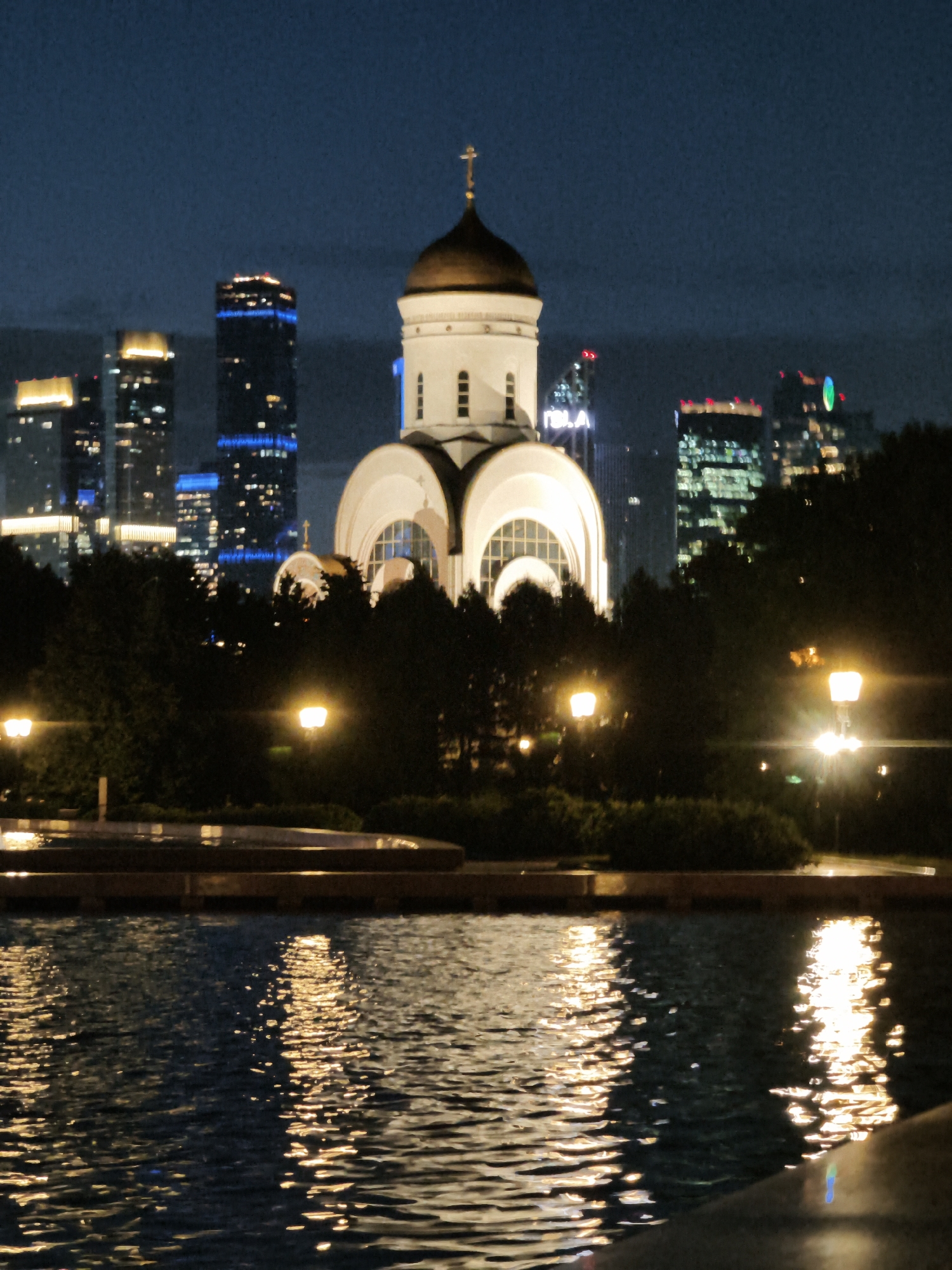 Night lights along the Moskva River — church, fountain, city skyline