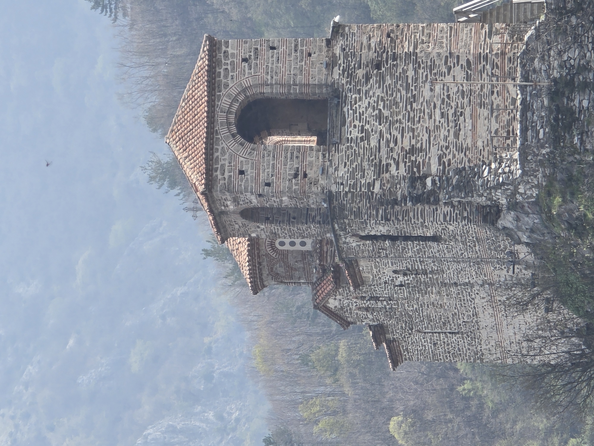 Historic cliffside church observed in misty Bulgarian mountains