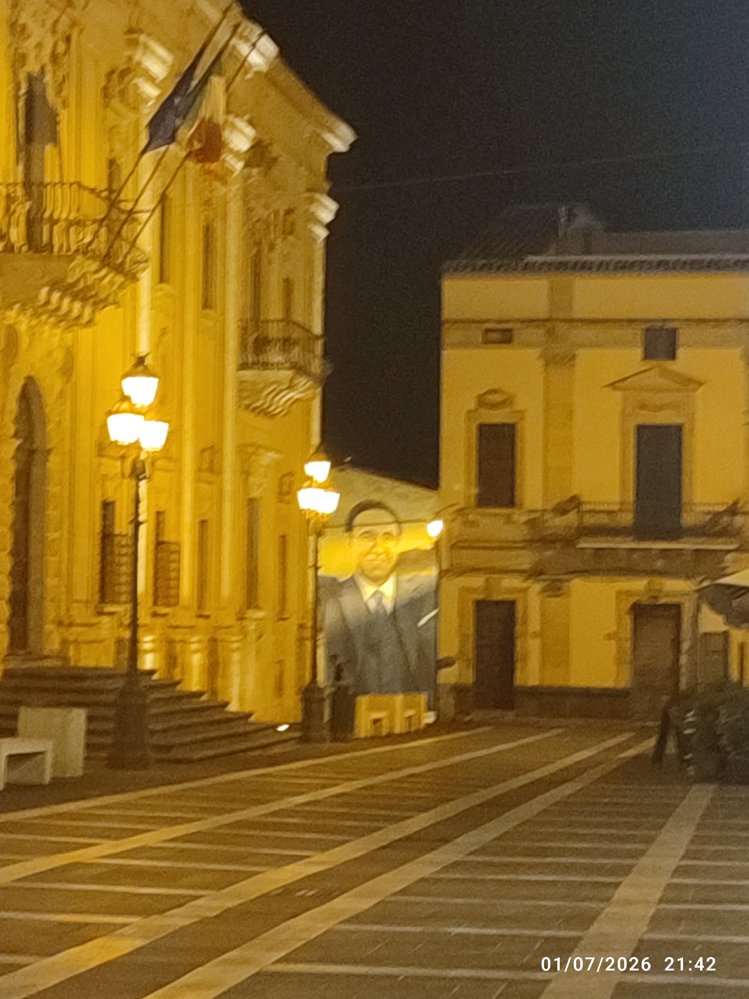 Sicilian piazza at night, lit facades and patterned stone