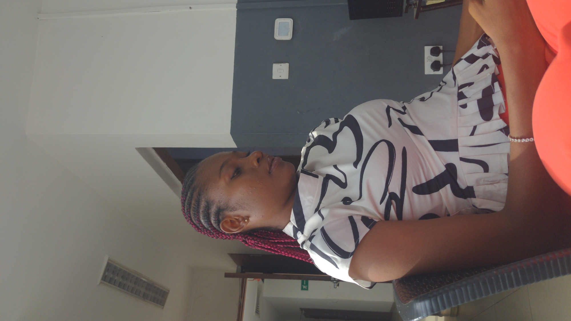 Woman with red braids captured in casual moments, Abuja