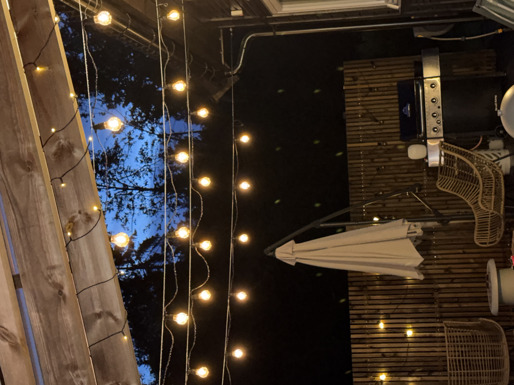 String lights over a Norwegian patio at dusk
