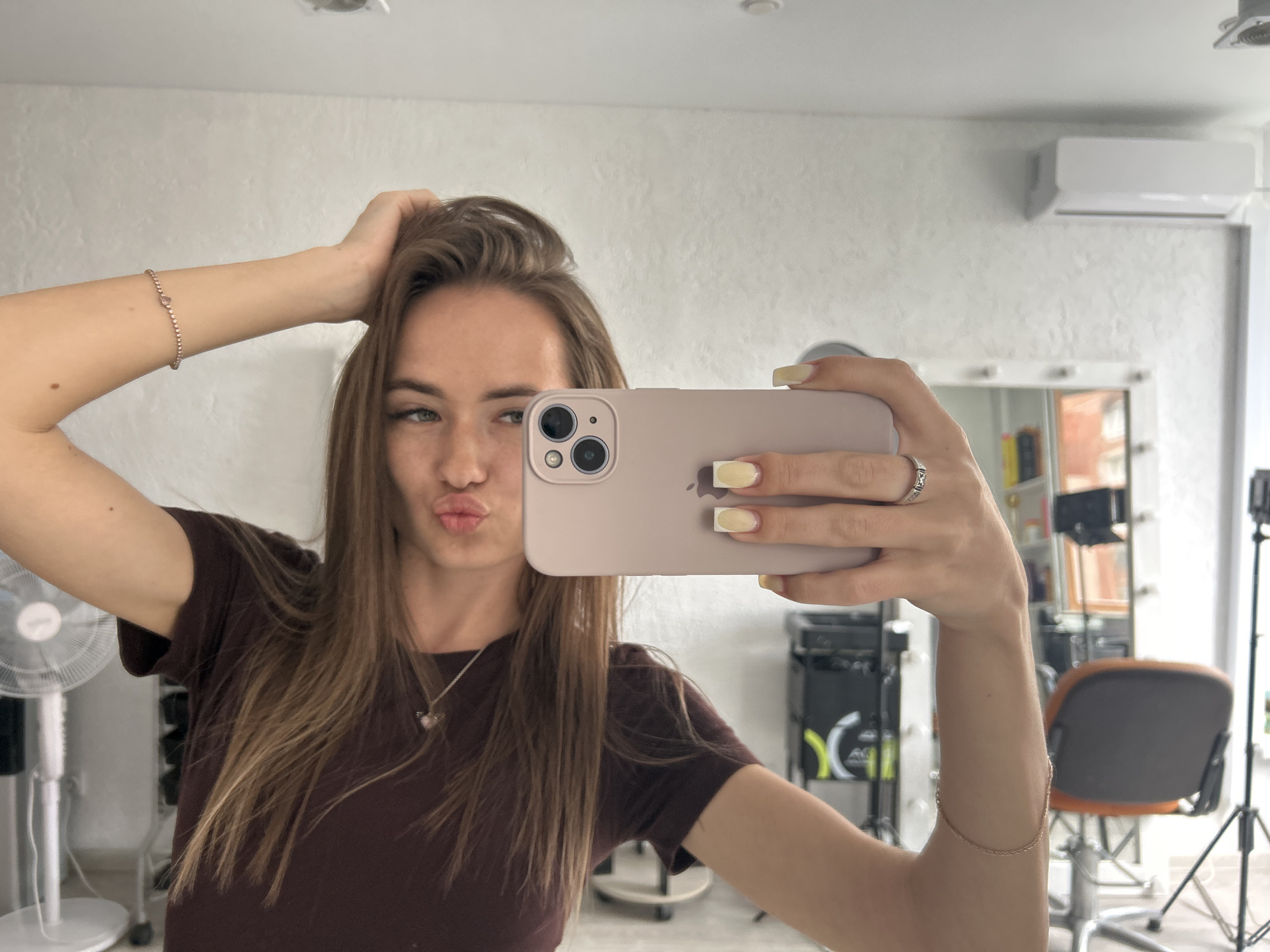Woman takes series of mirror selfies in salon setting