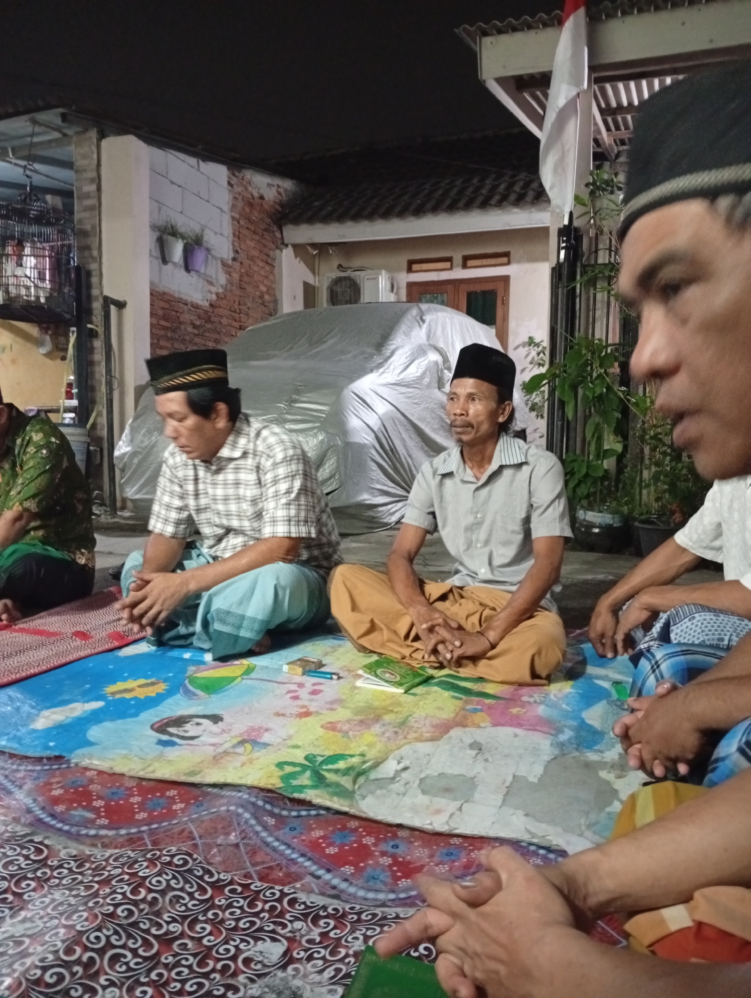 Outdoor Islamic study session on woven mats in Caringin