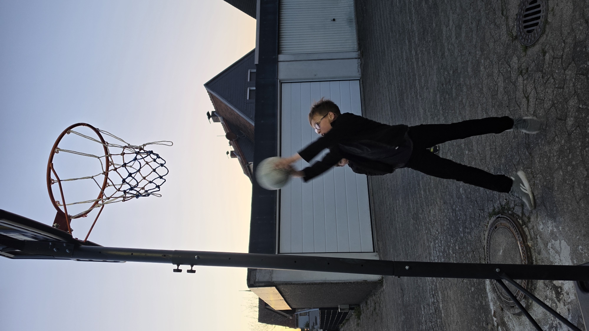 Young basketball player captured mid-shot at Ihringshausen outdoor court