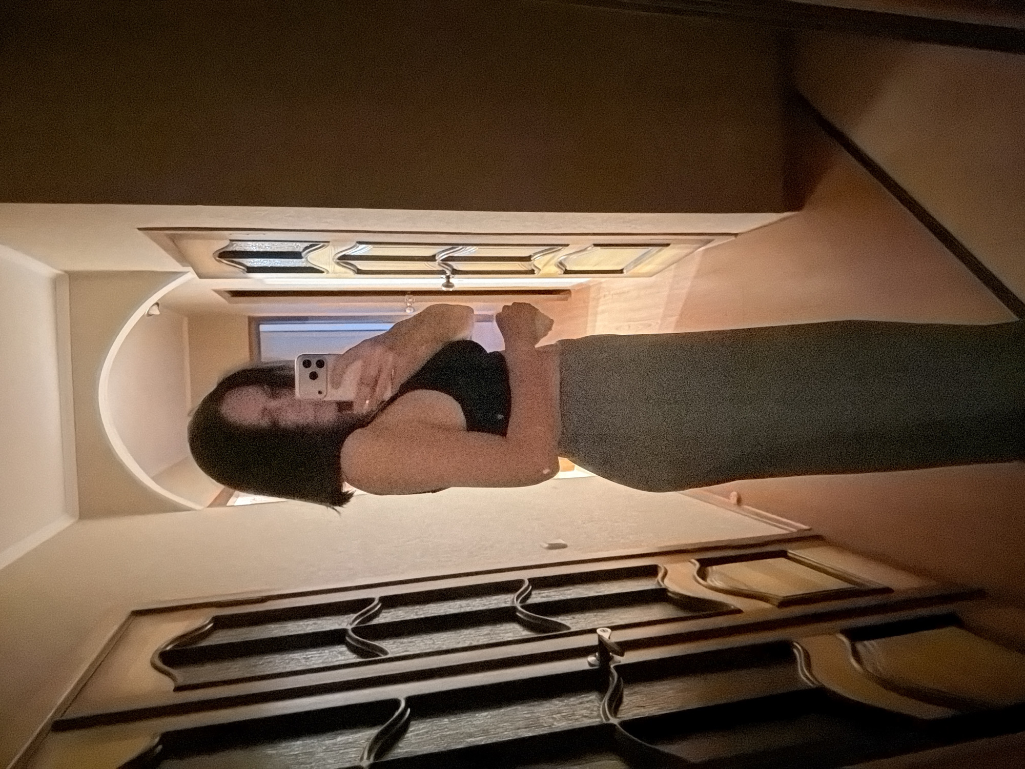 Person takes mirror selfies indoors during evening hours