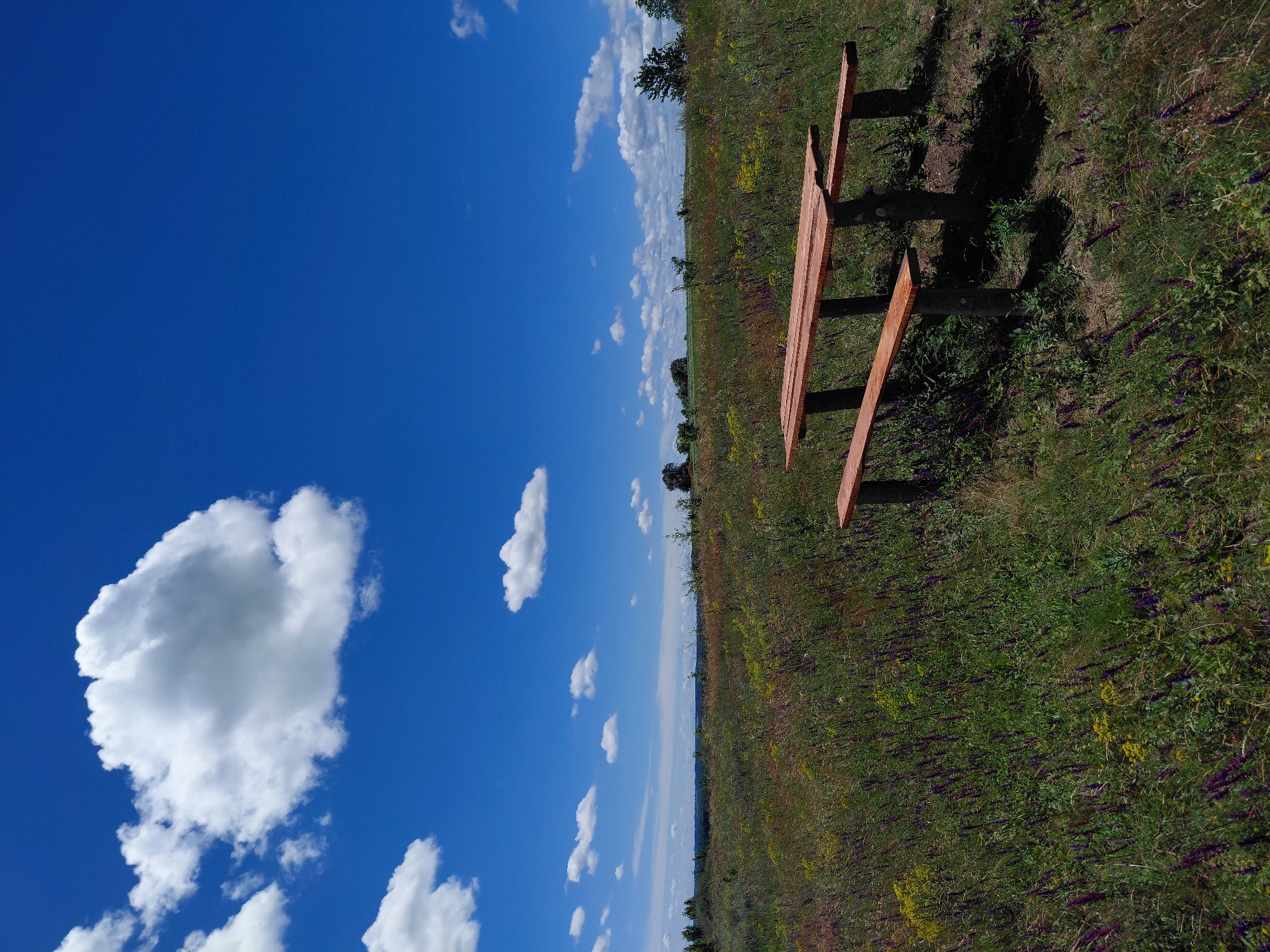 Rural hillside views with wooden benches in Ustyvytsia countryside