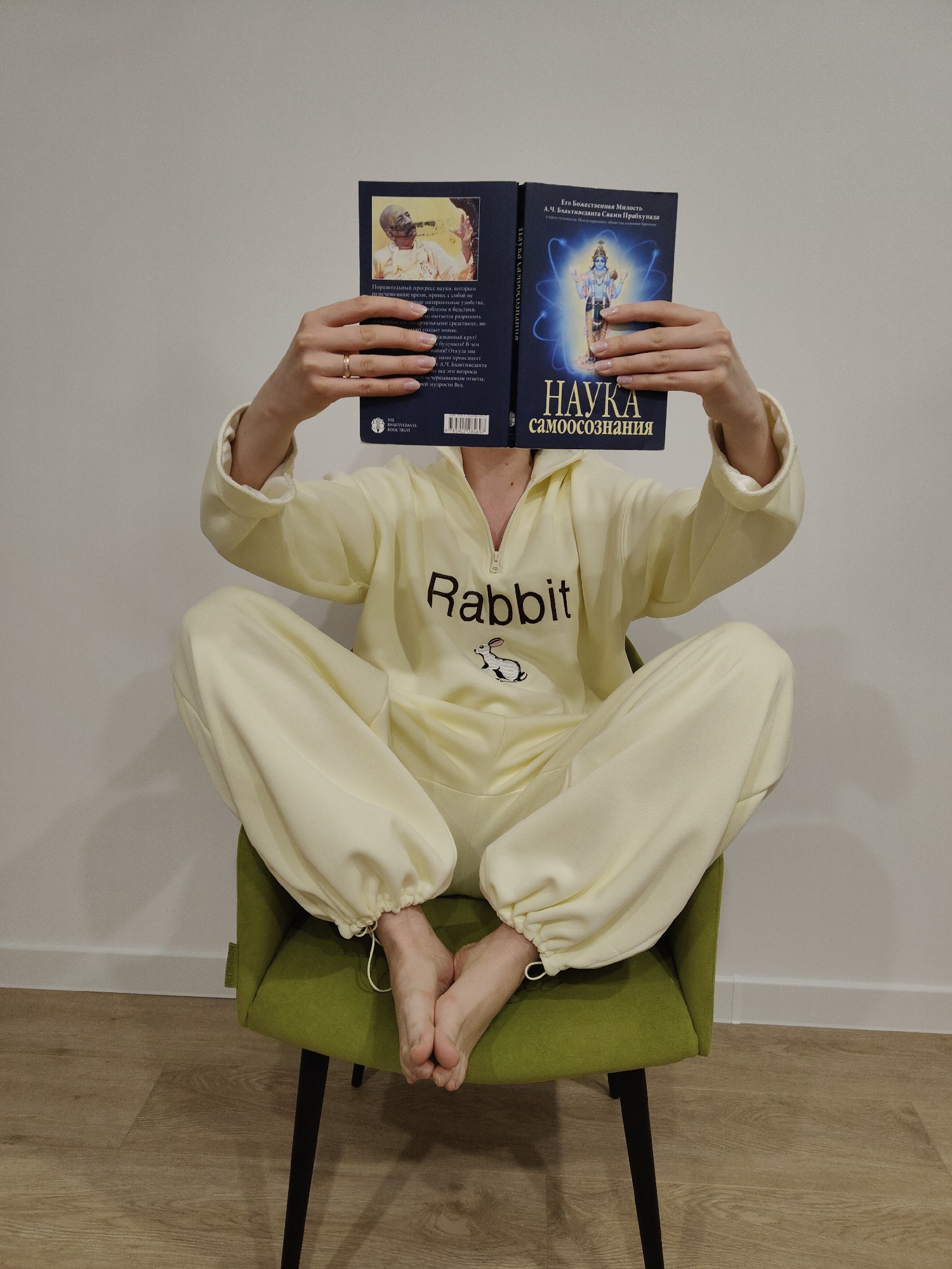 Reader in yellow tracksuit, hand shadows observed indoors
