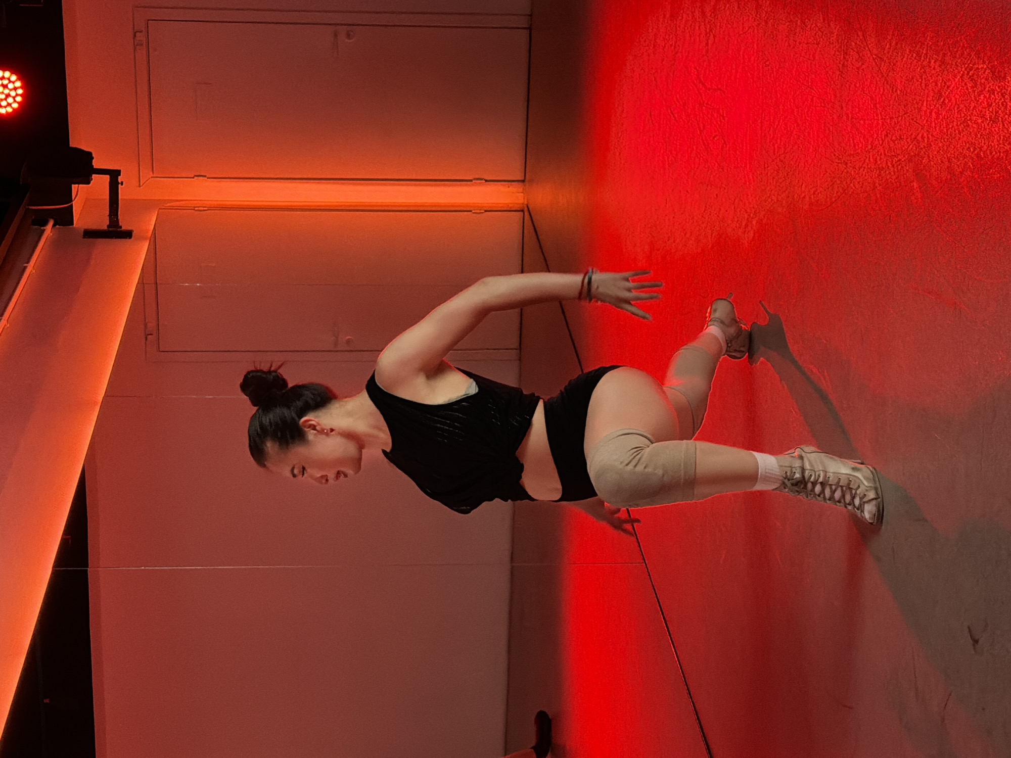 Woman practices dance in red-lit Moscow studio
