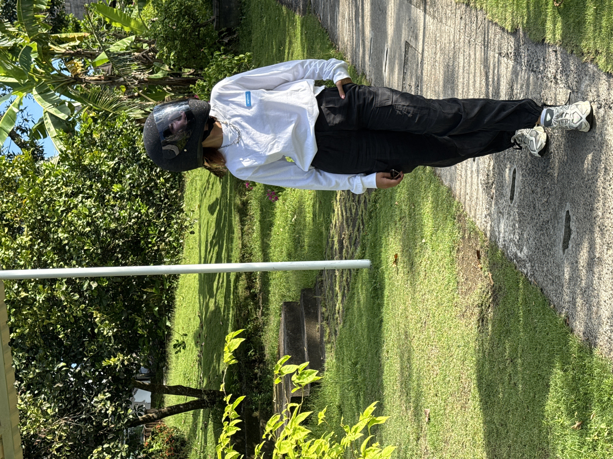 Motorcyclist stops in garden setting in Buduk, Indonesia