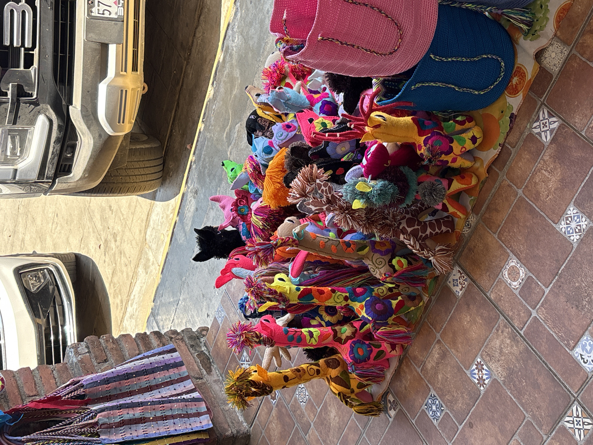 Colorful handcrafted toys displayed by roadside vendor in Puerto Escondido