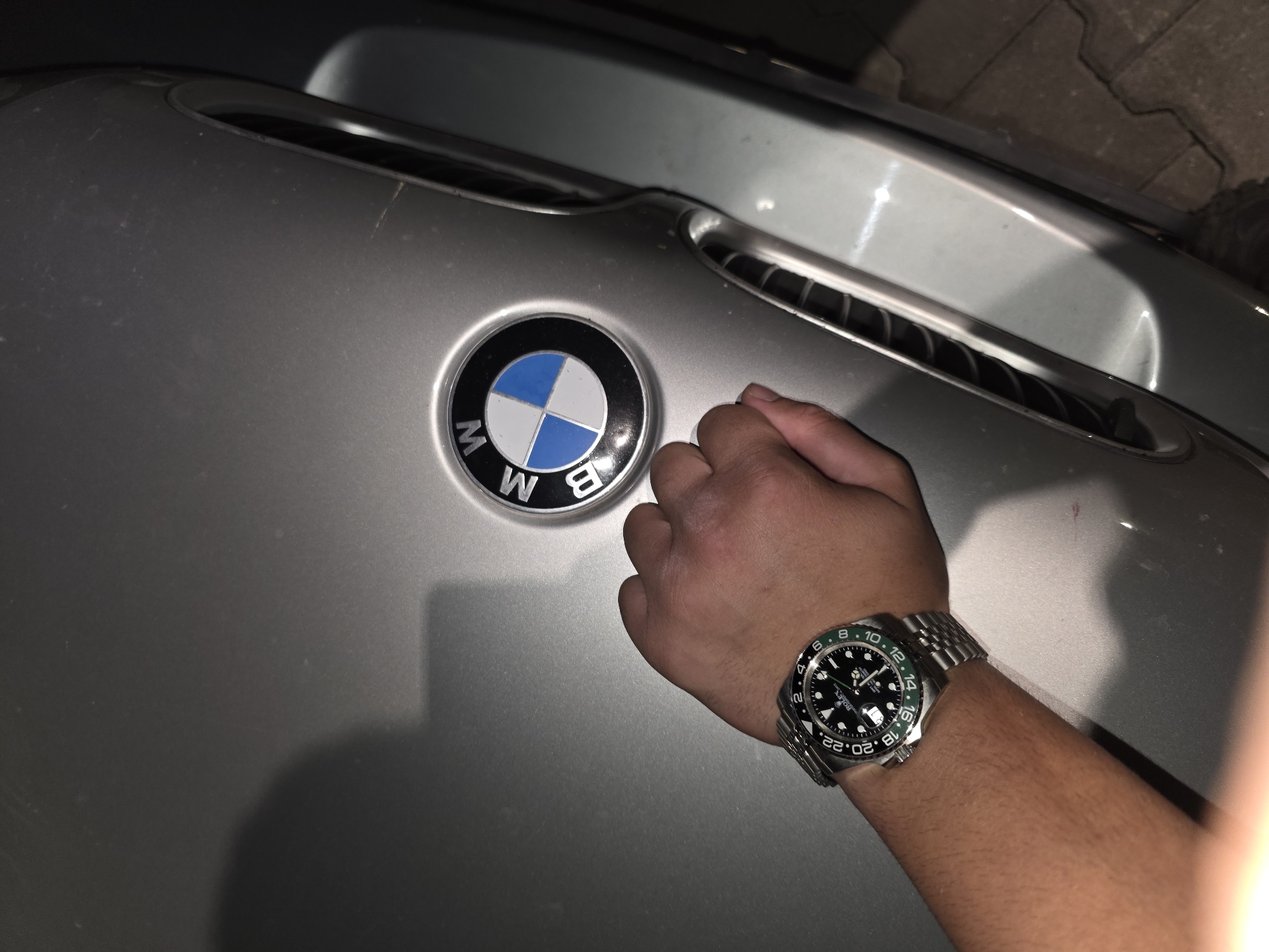 Luxury watch displayed near BMW in nighttime Sevlievo scene