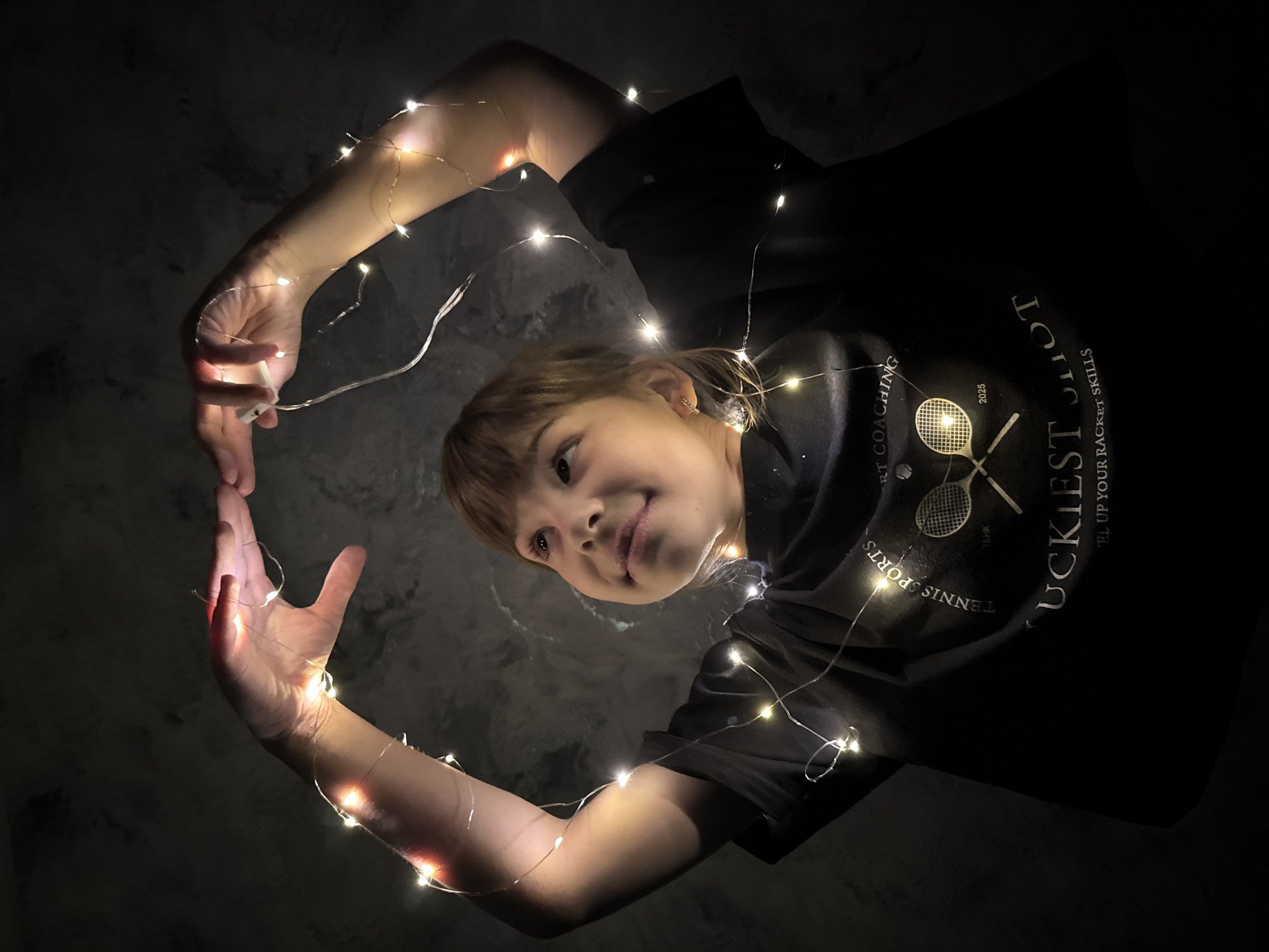 Children play with string lights indoors in Russia