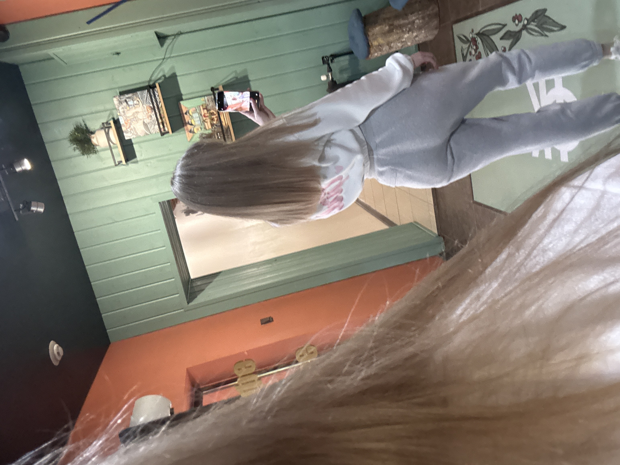 Woman takes selfie in colorful painted room with decor