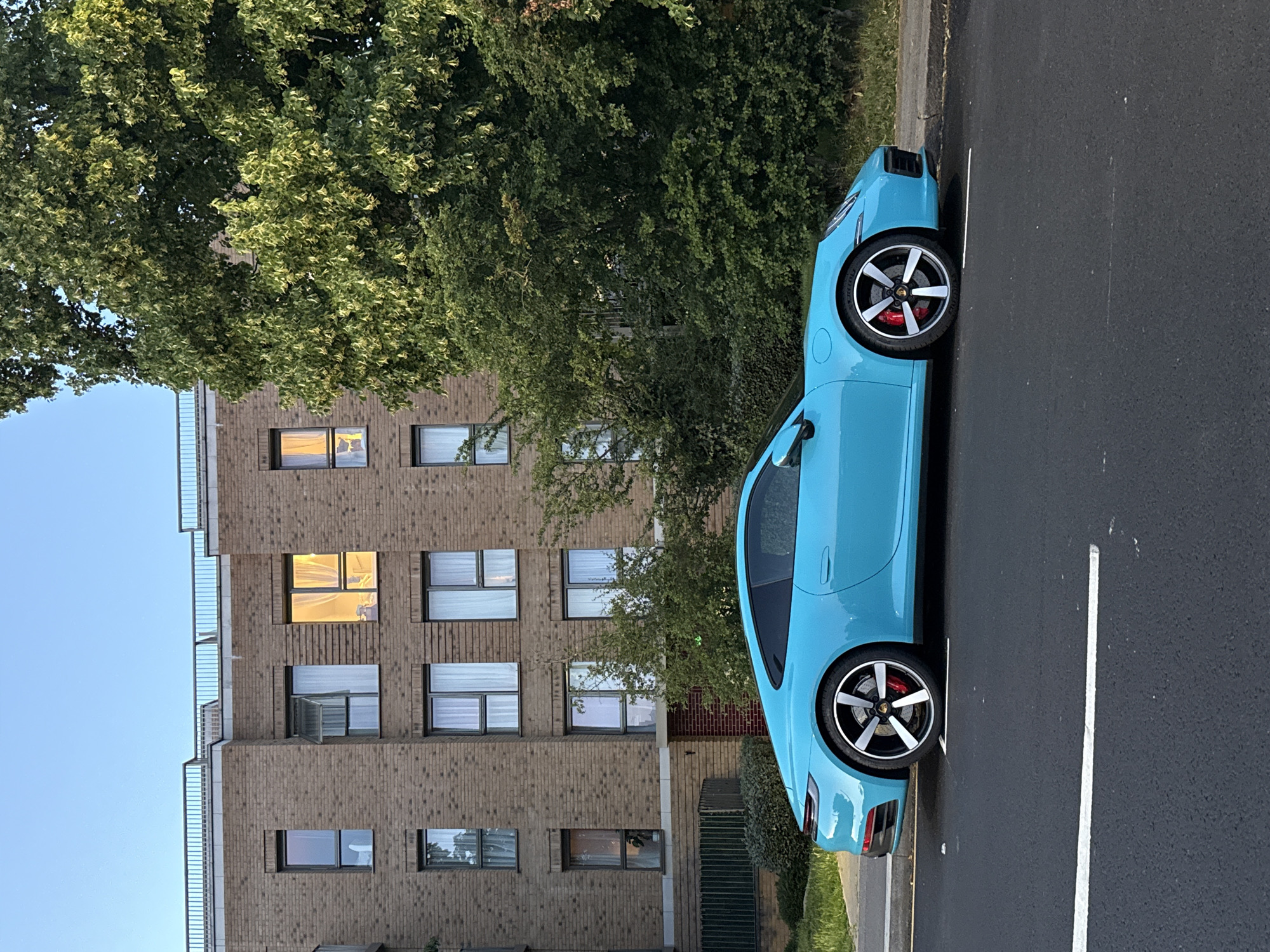 Cyan Porsche and crescent moon on a London summer evening