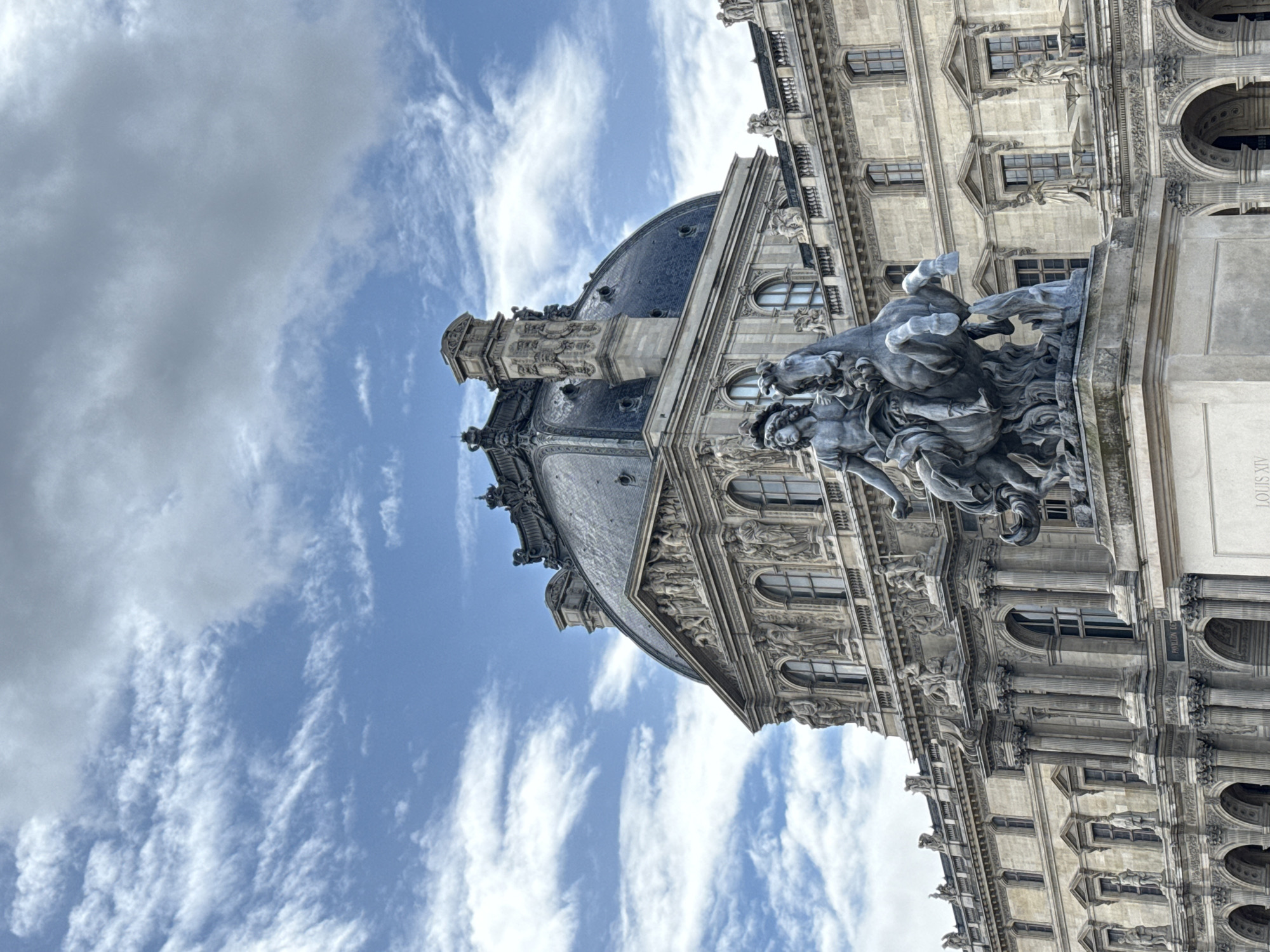 Tourist documents Louvre's architecture during morning museum visit