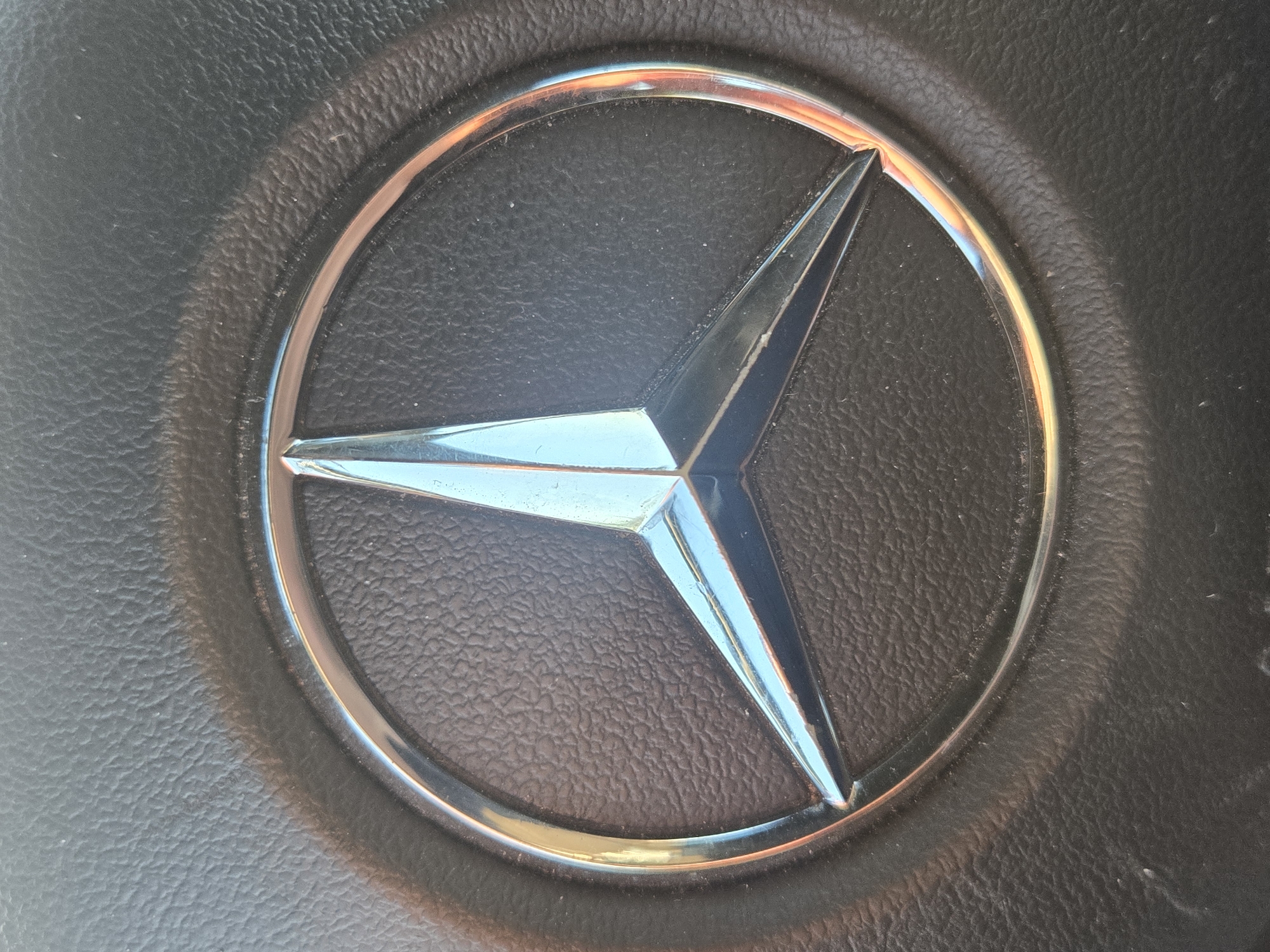Mercedes-Benz logo captured on vehicle steering wheel
