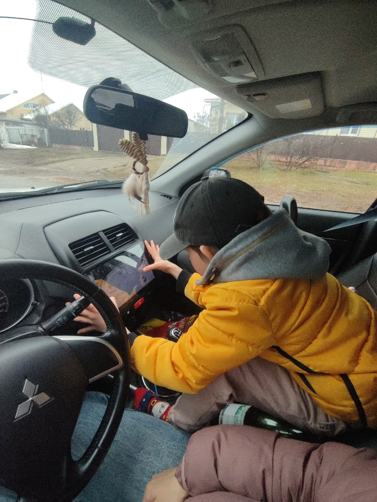 Child operates dashboard screen in Mitsubishi passenger seat, Russia