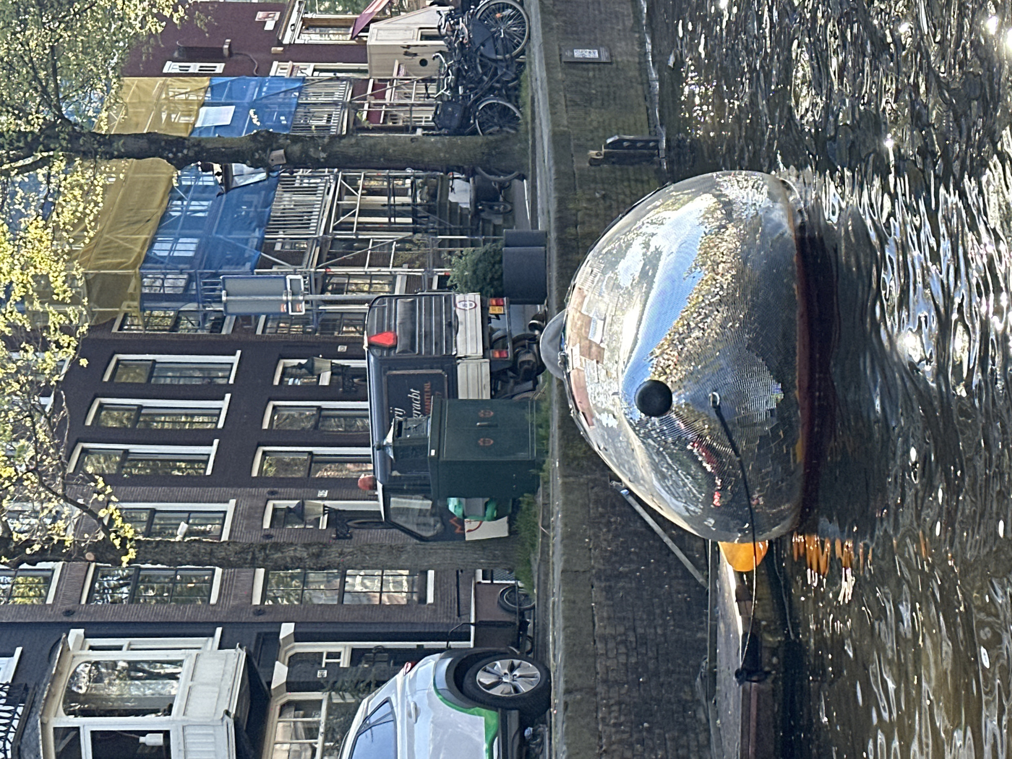Canal boat tour navigates Amsterdam waterways on sunny afternoon