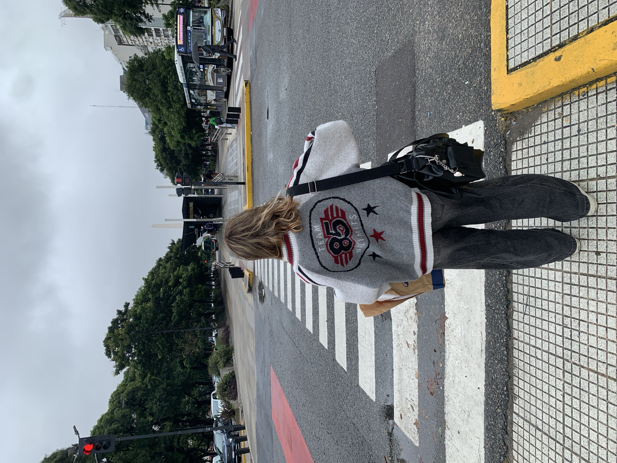 Person crosses street in Buenos Aires wearing striped sweater