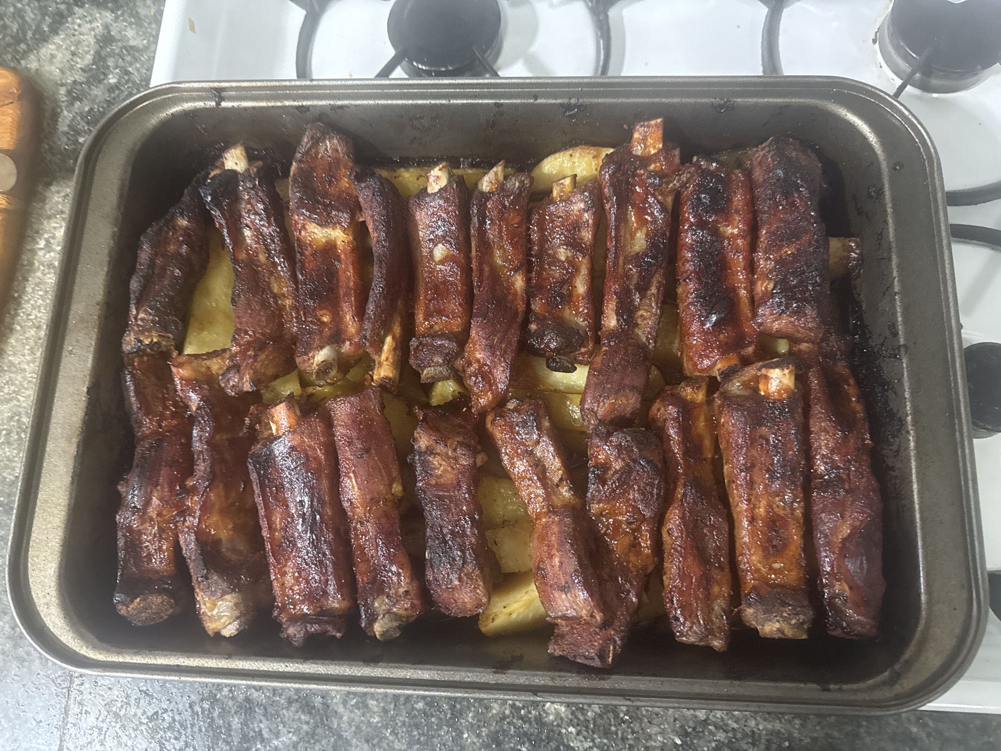 Home-cooked ribs and potatoes prepared in baking tray