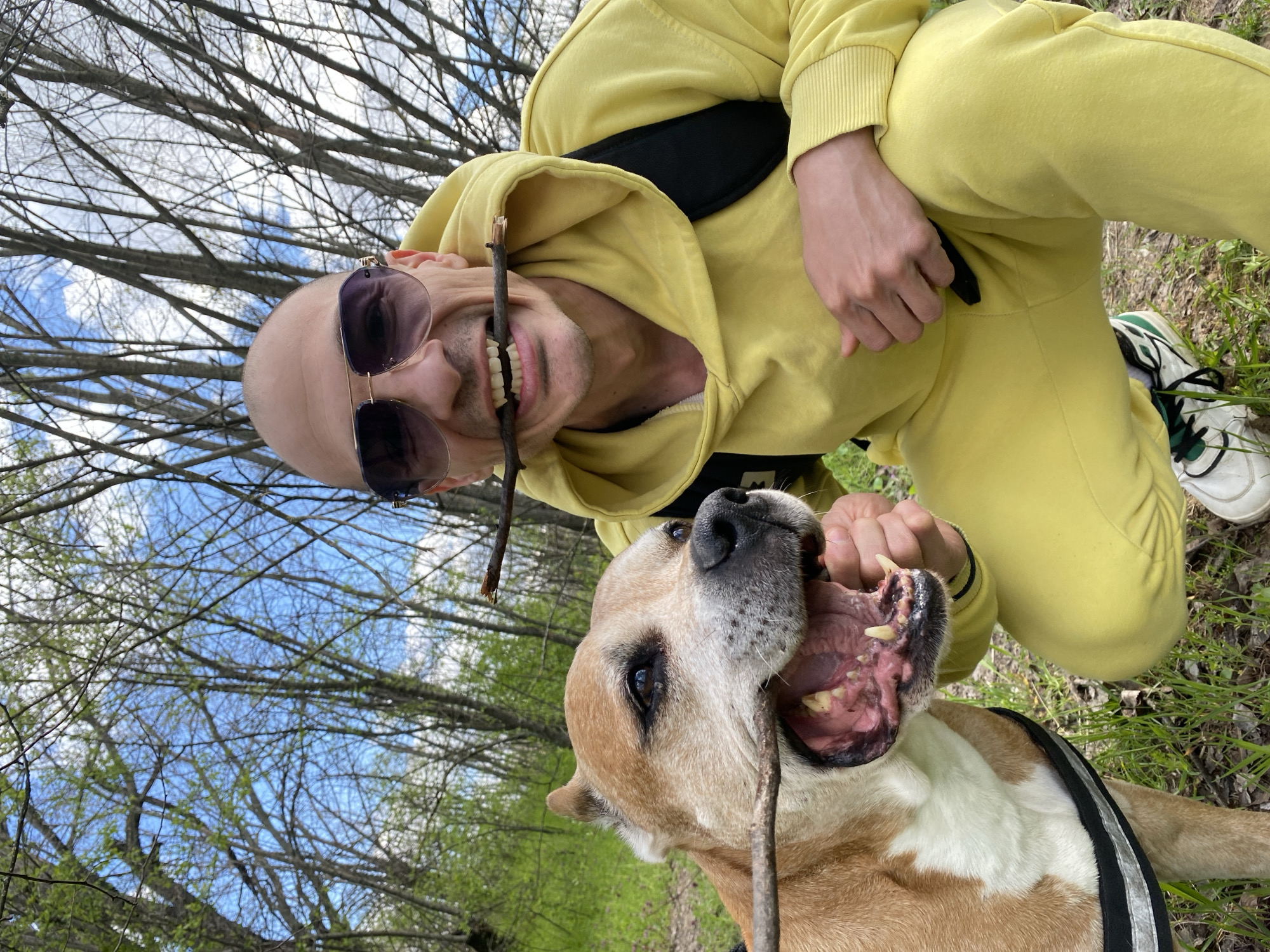 Man in yellow tracksuit plays with dog in Pleven park