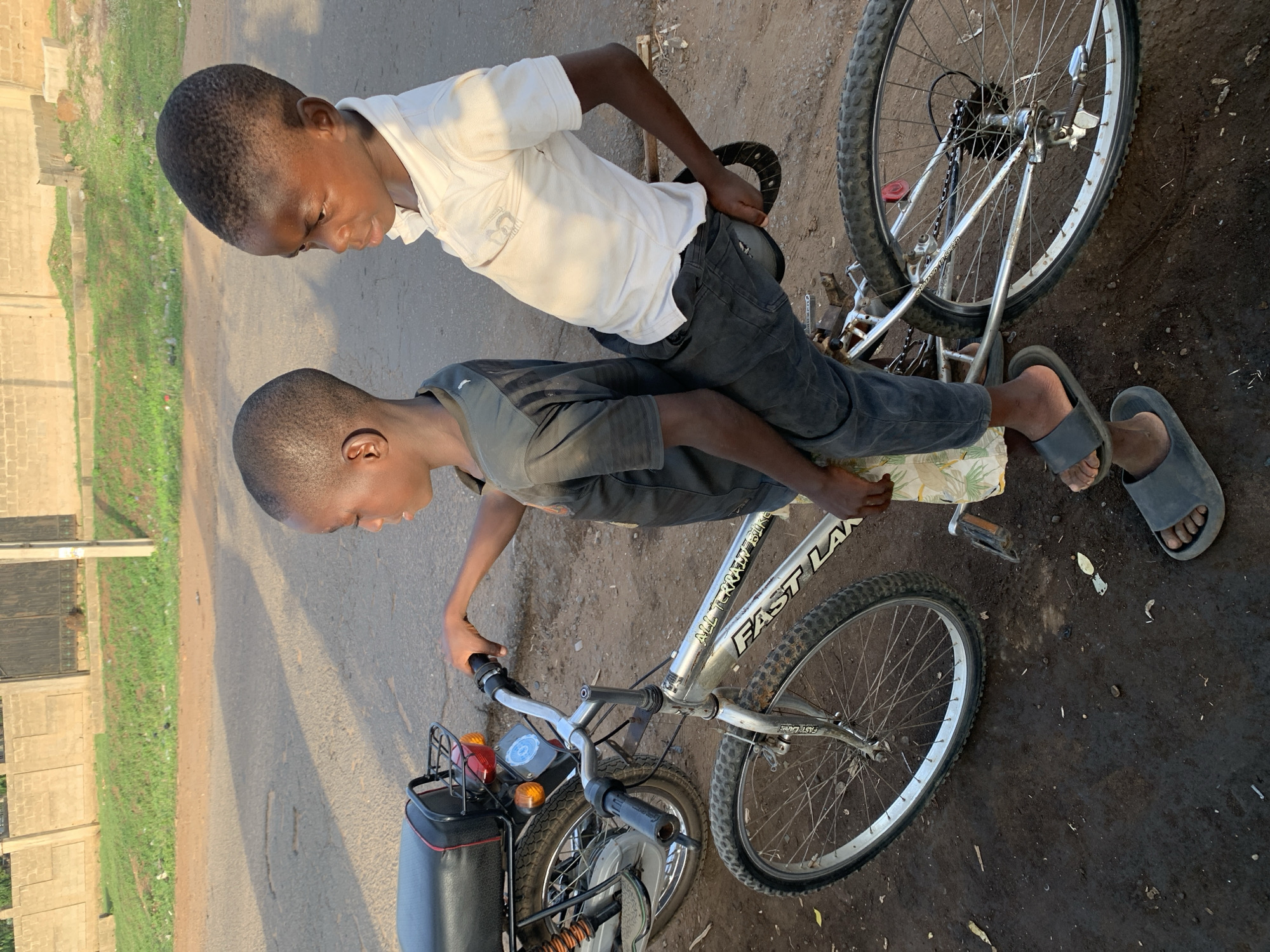 Two boys share bicycle moment in Kabba, Nigeria