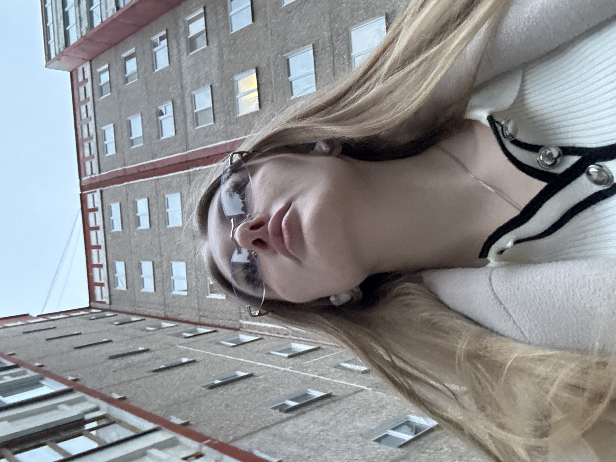 Woman takes selfies near apartment building in Perm, Russia