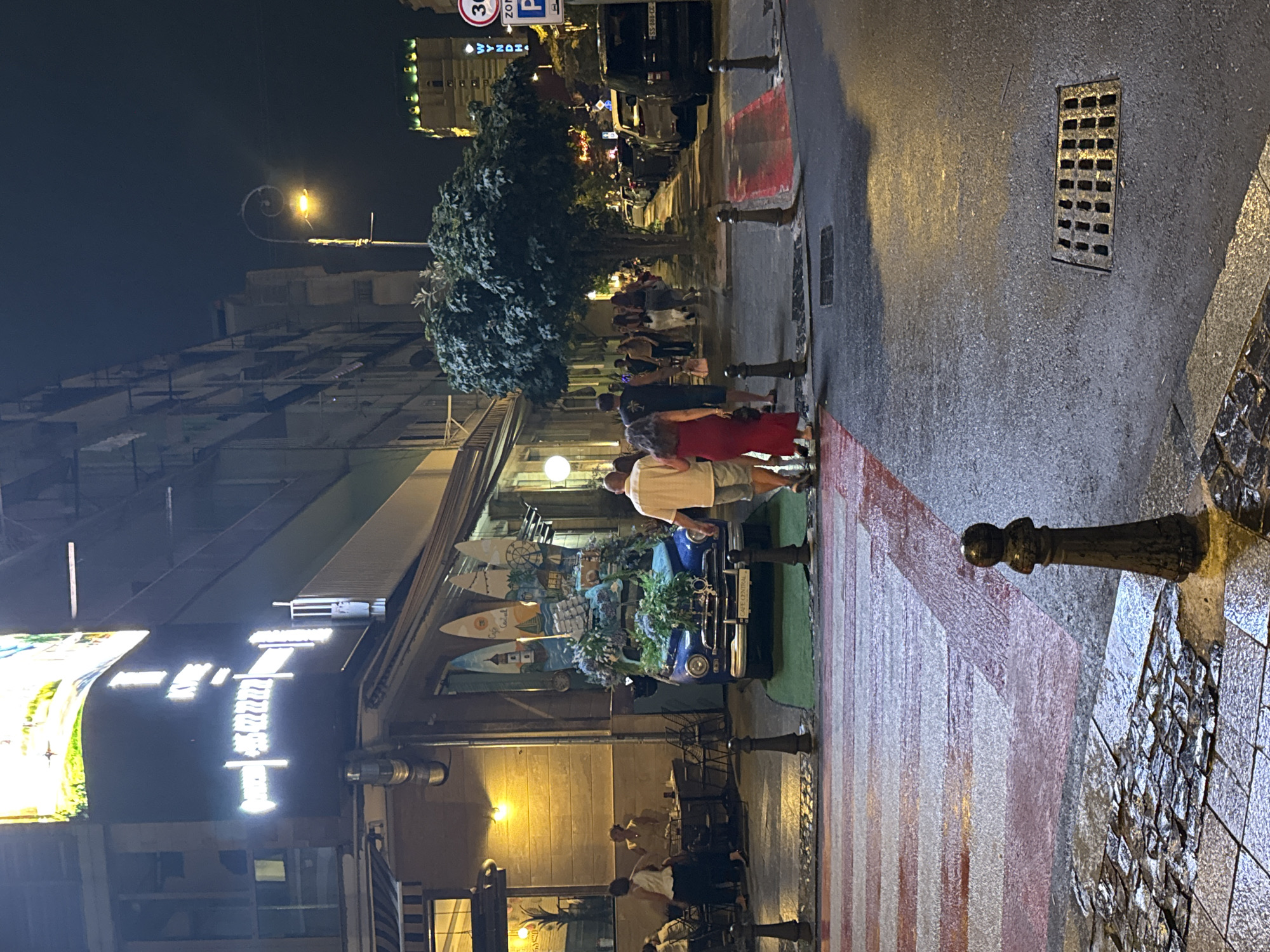 Rainy night on Batumi's Rustaveli Avenue, flower-decked vintage car