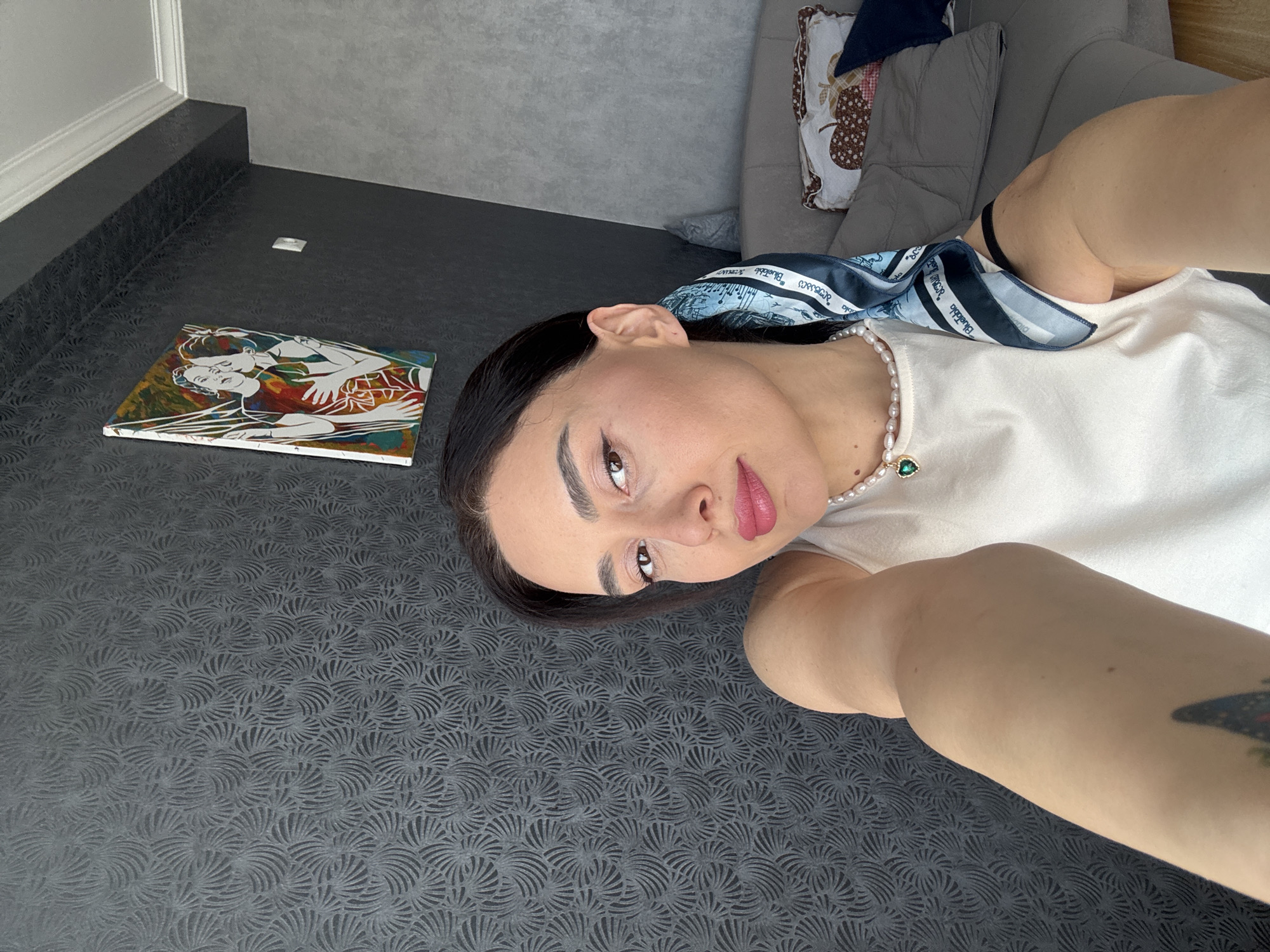 Woman takes morning selfies on sofa in Tbilisi apartment