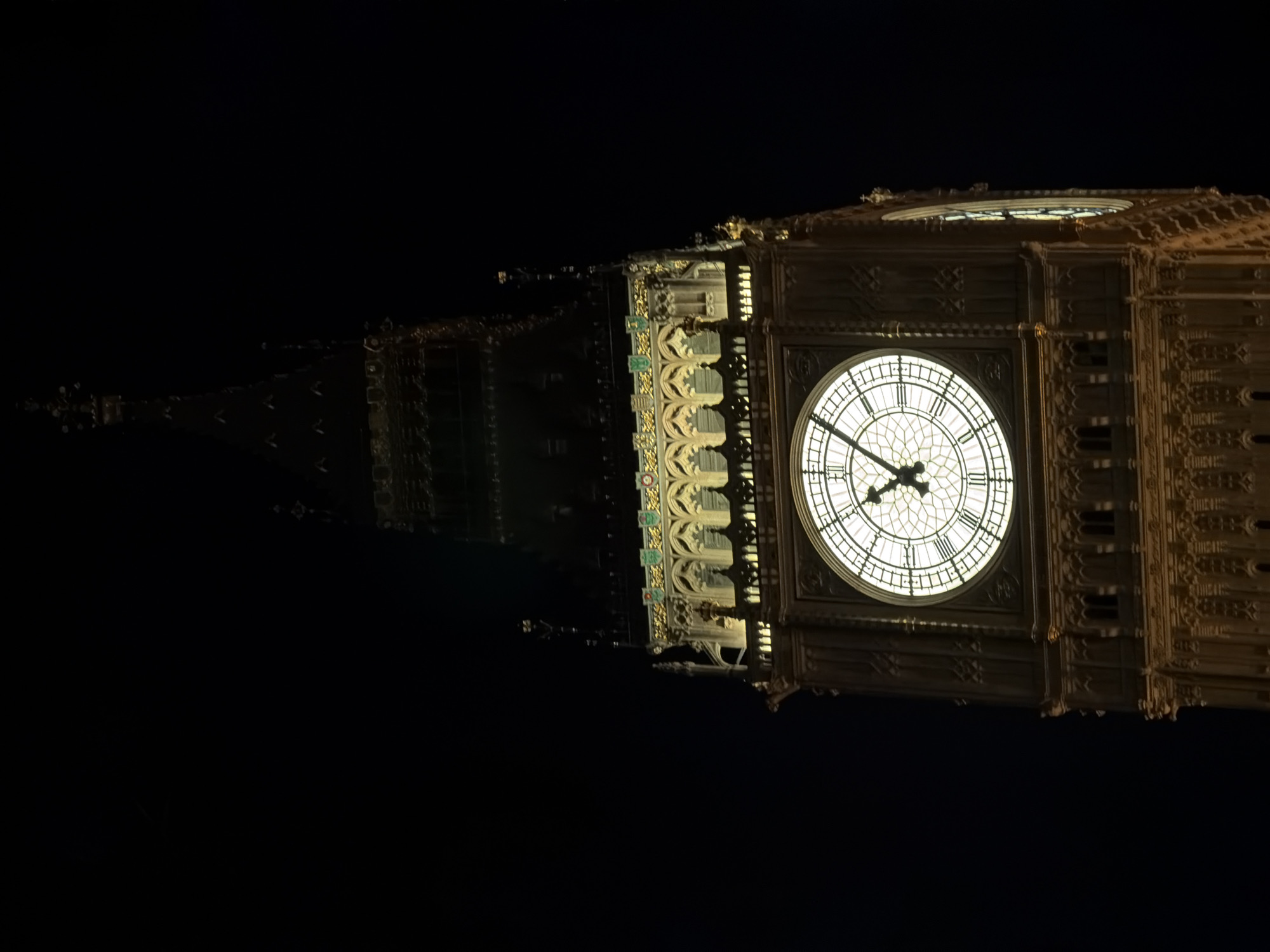 Big Ben clock face photographed illuminated at night