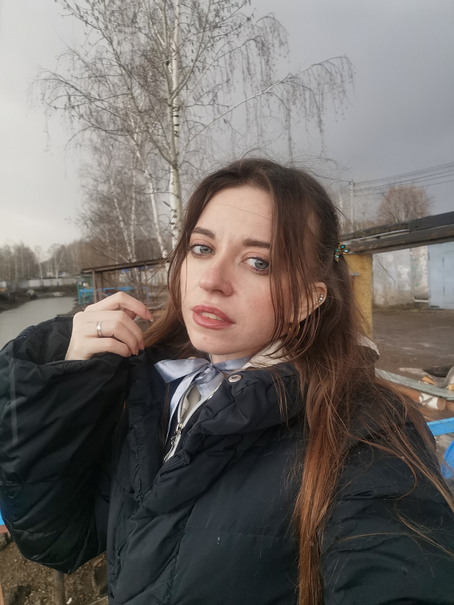 Woman documents rainy waterfront visit with selfies, duck sightings