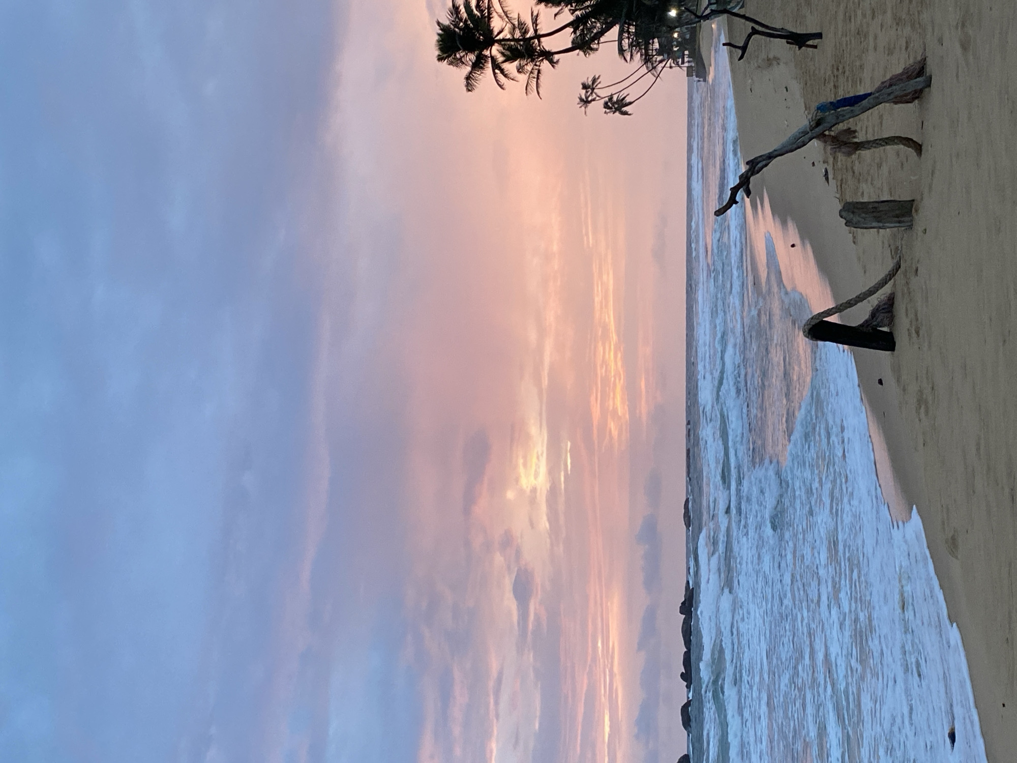 Hikkaduwa beach at sunset, calm waves and palm trees