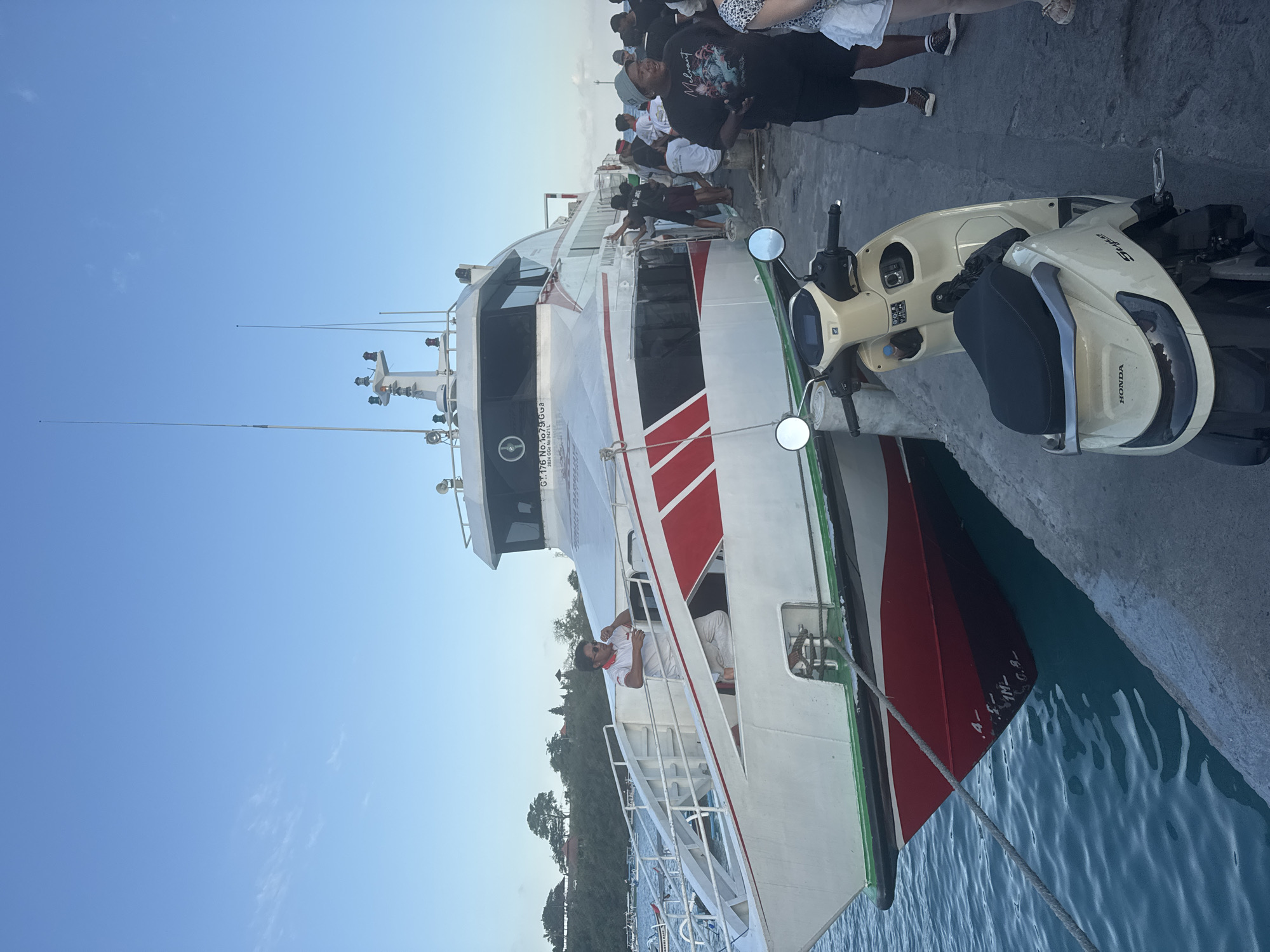 Ferry activity at Manggis pier, passengers and boats gathered