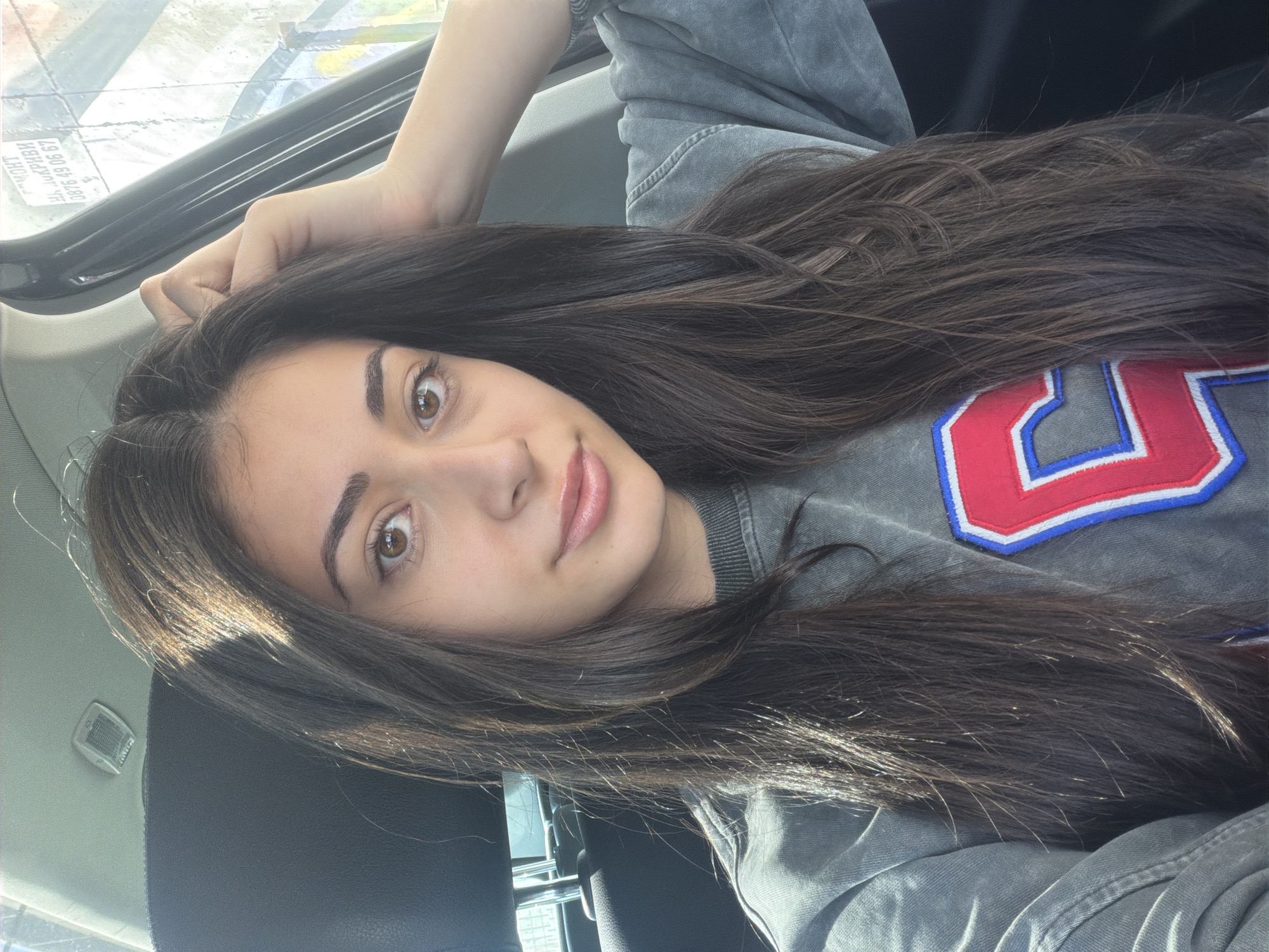 Woman photographed in car wearing numbered sweatshirt in Sofia