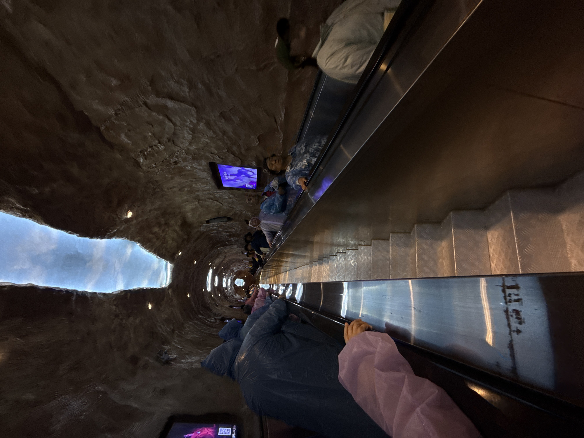 Escalator operates in tunnel structure with sky visible