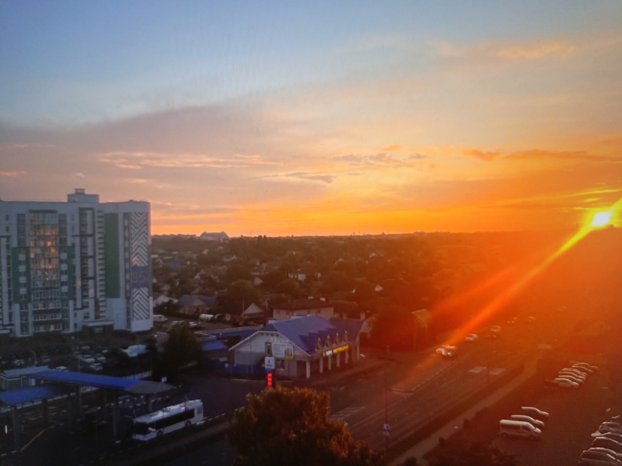 Dusk over Brest: city skyline, highway, and a ceramic skull
