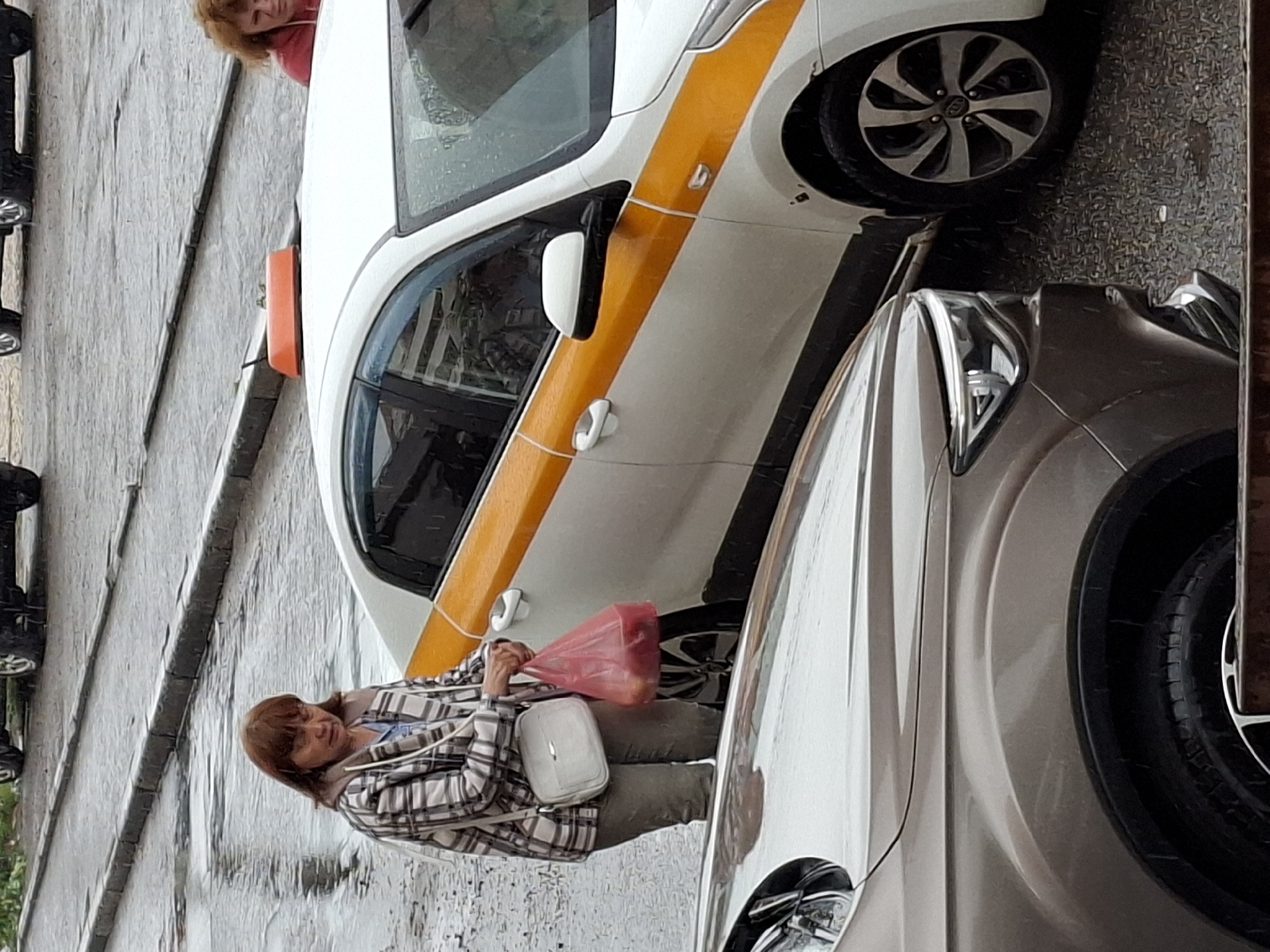 Rainy urban street scene with taxis, pedestrians, and shopping bags