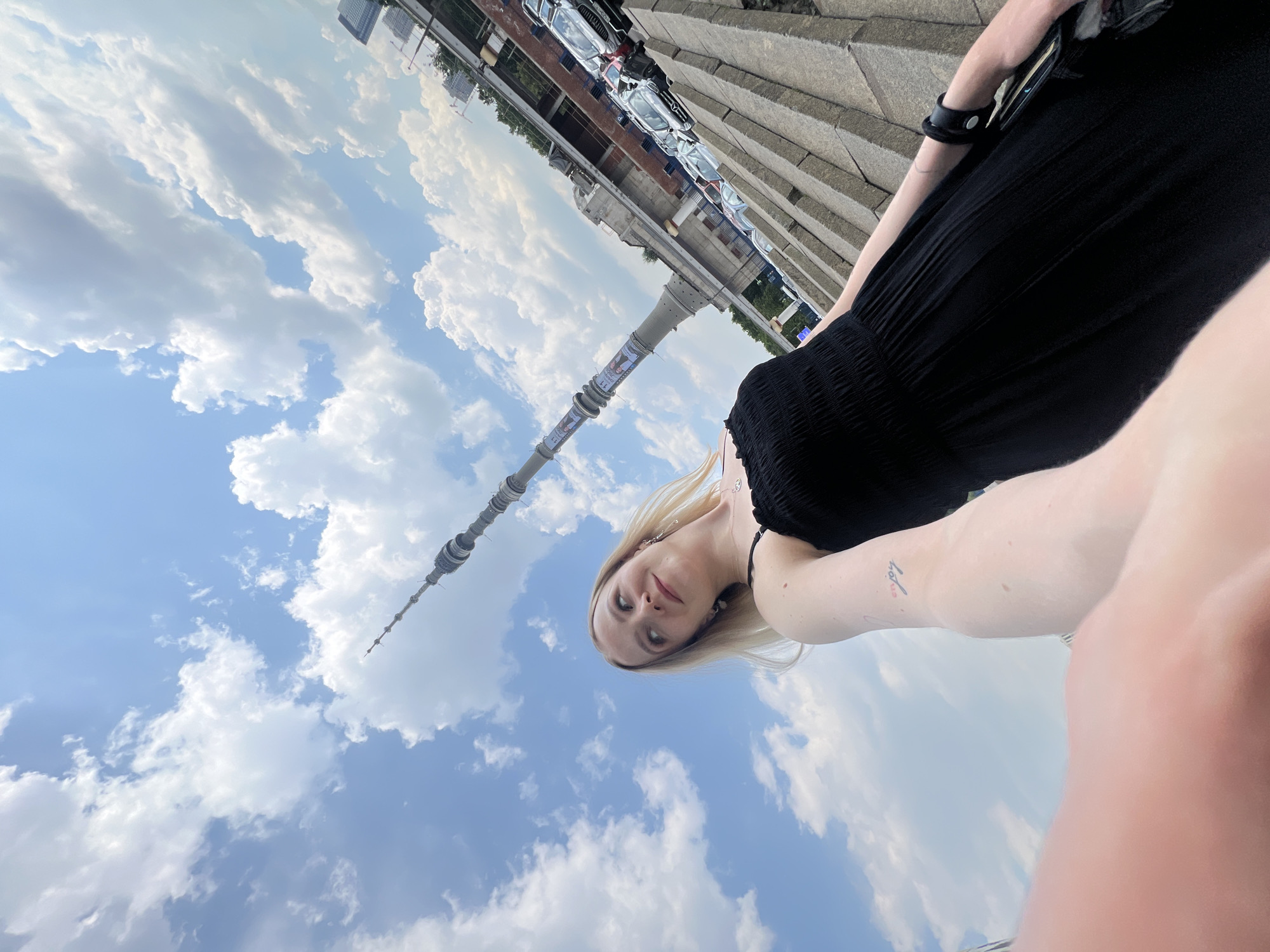 Woman takes selfies with Ostankino Tower in Khimki, Russia
