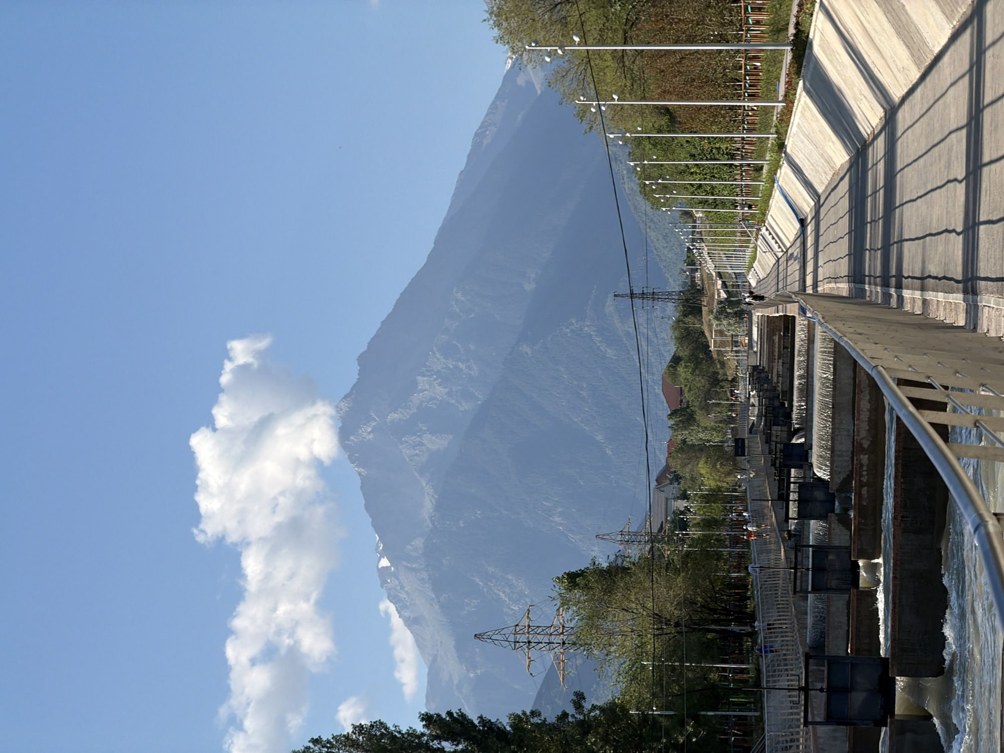 Snow-capped peaks and a paved path on Almaty's mountain edge