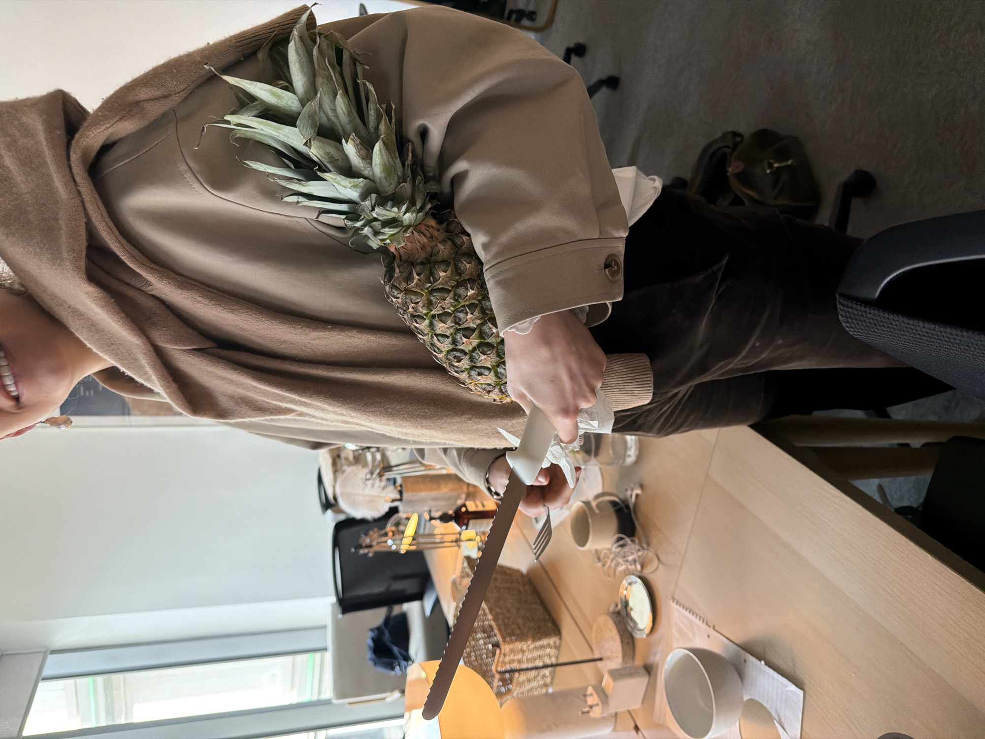 London office worker prepares fresh pineapple for desk snack