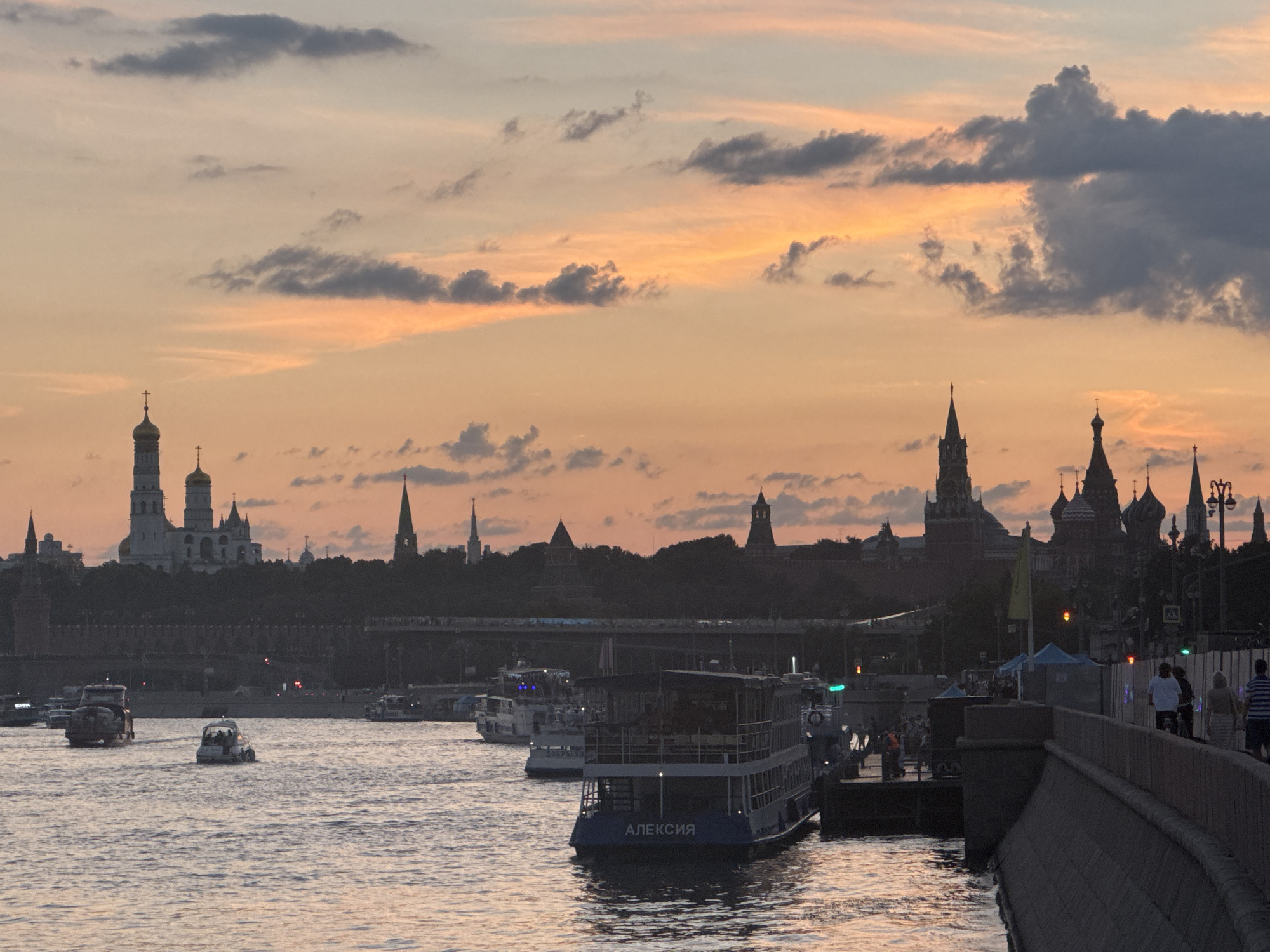 City skyline and boats at sunset, sky reflected on water